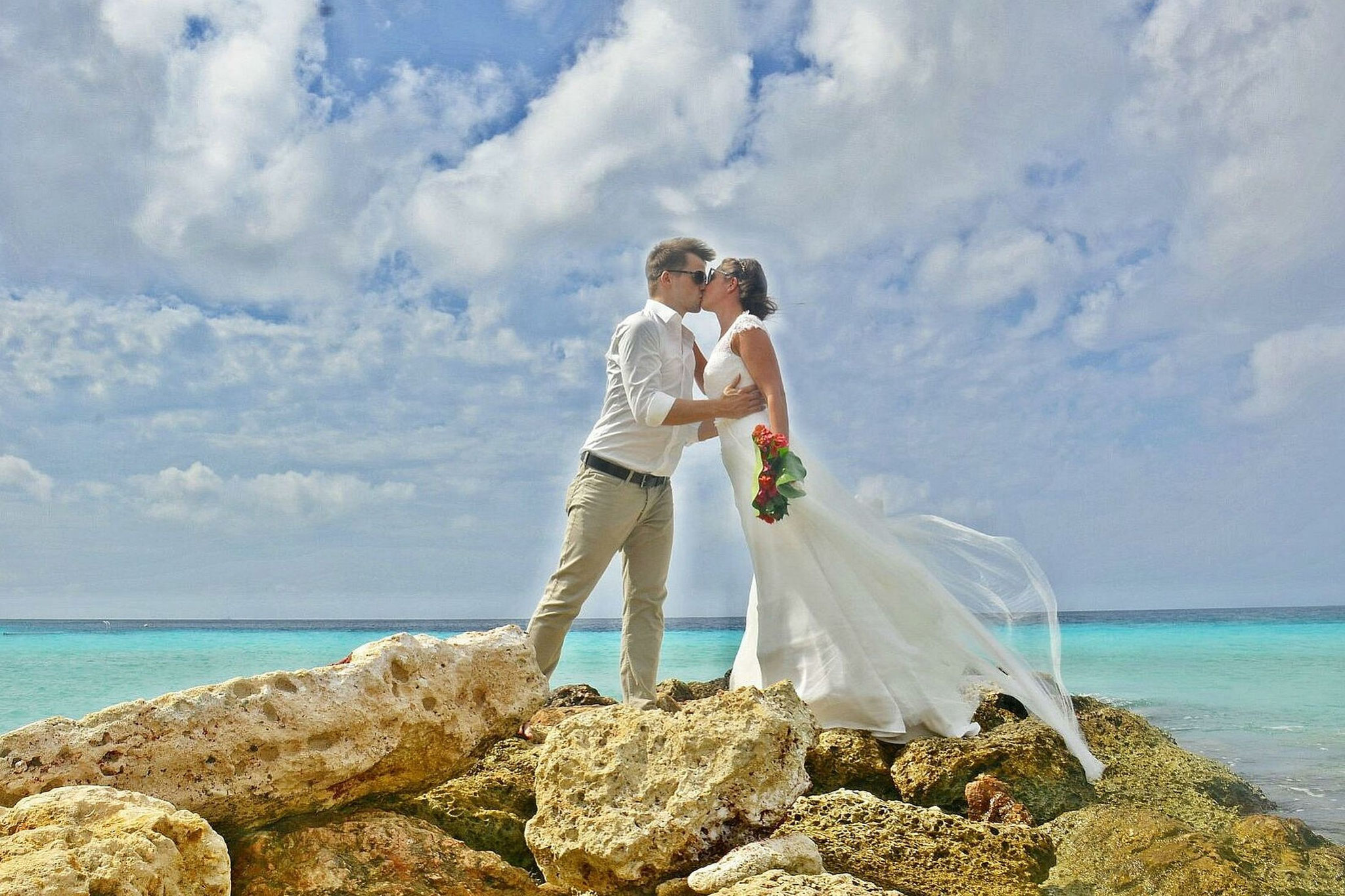 Brautpaar am Strand auf Felsen – Destination Wedding am Meer Paarshooting auf Curacao