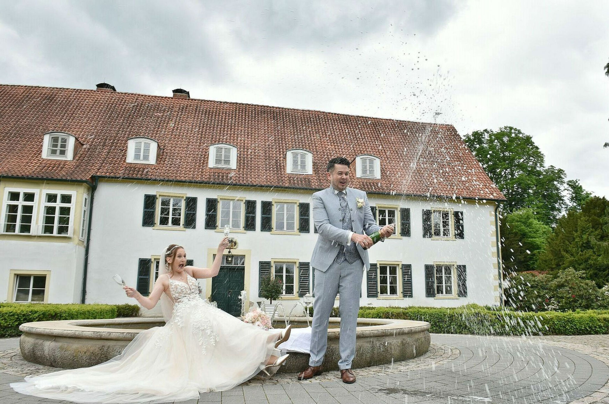 Hochzeitsfotograf Schlosshotel Münchhausen - Brautpaar mit Champagnerdusche