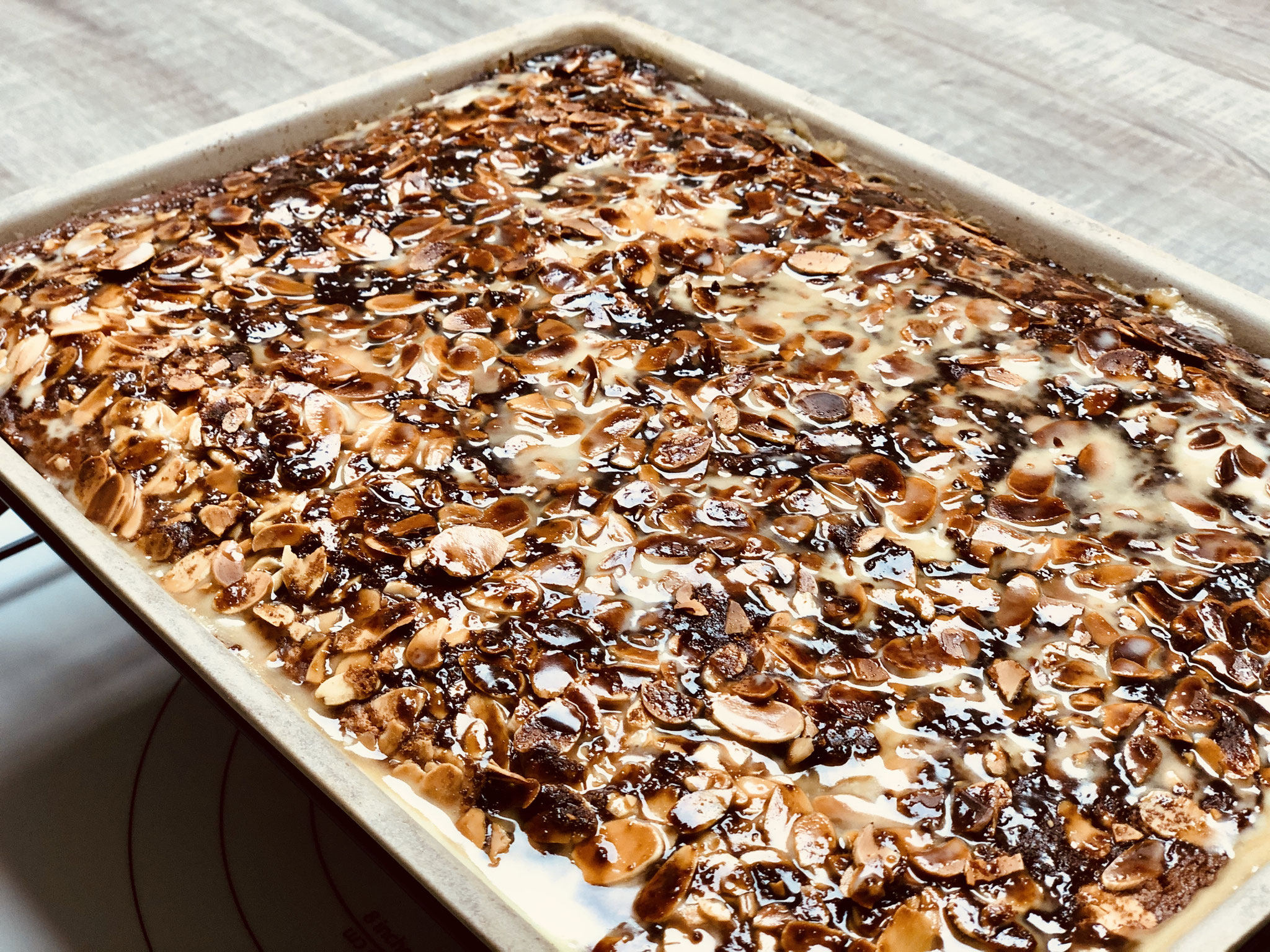 Nach dem backen, den Ofenzauberer auf das Abkühlgitter/Kuchengitter stellen und dann Löcher in den Kuchenboden stechen und die Sahne-Butter-Soße darüber gießen.