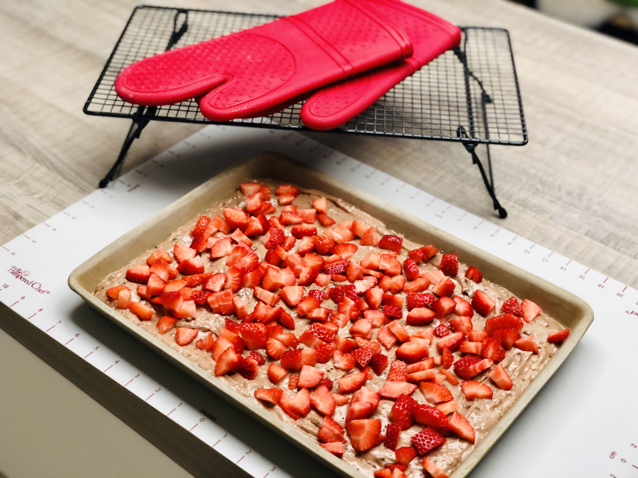 Den Teig in den Ofenzauberer fließen lassen und glatt streichen und darauf die geschnittenen Erdbeeren verteilen...
