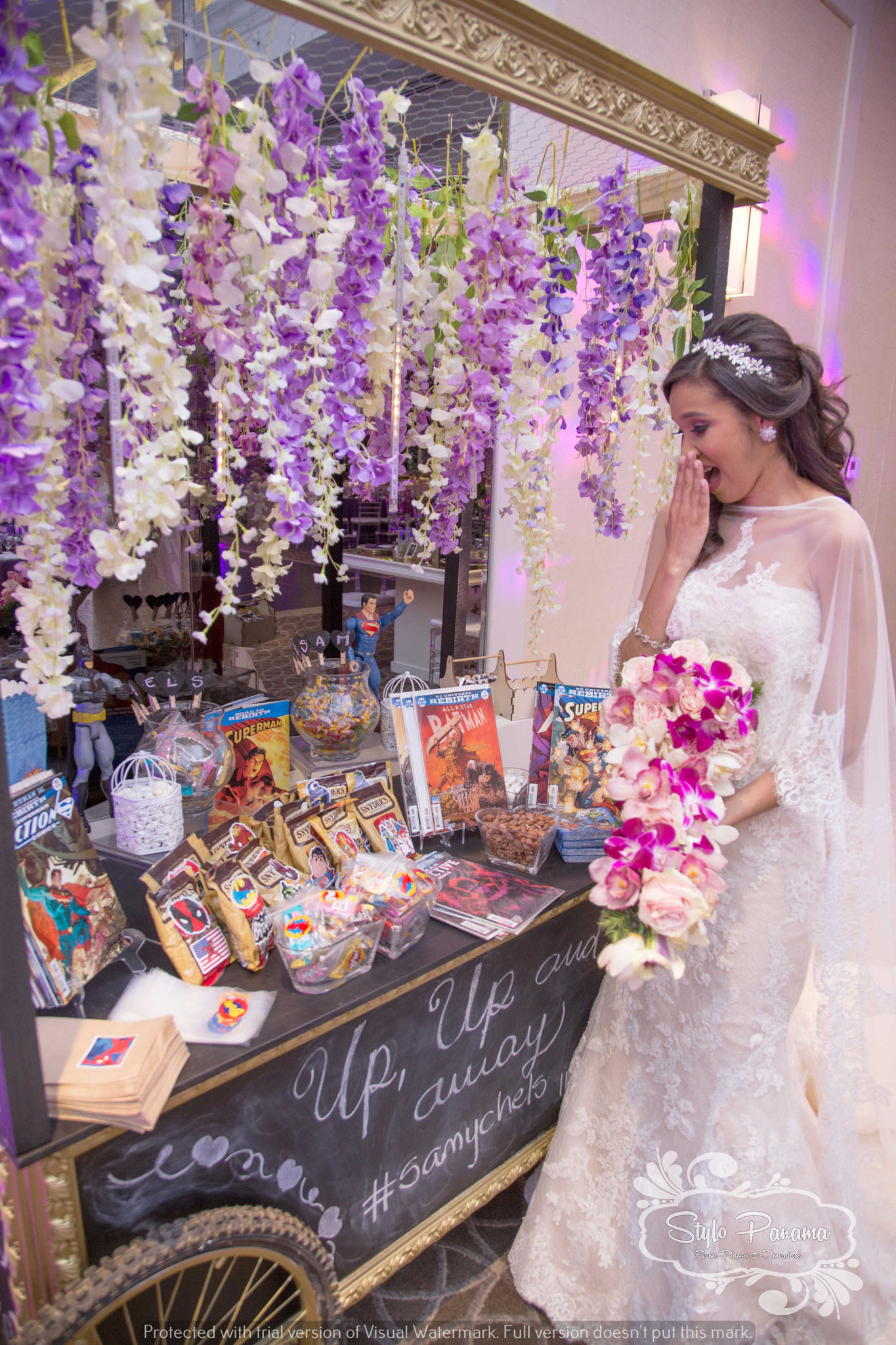 Novia junto al candy bar sorpresa para el novio, decorado de acuerdo a su hobbie de historietas 