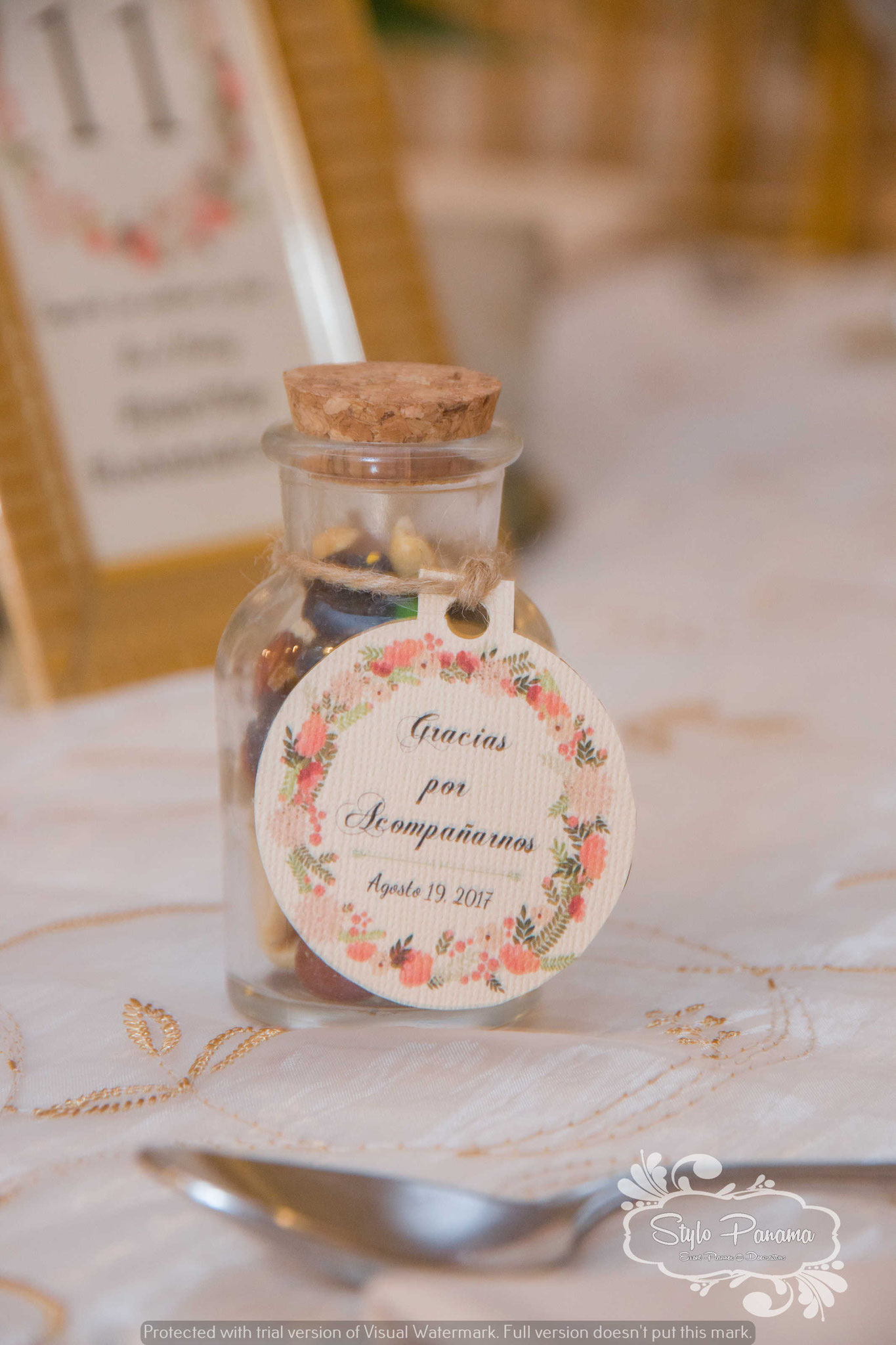 Mini masón jar con variedad de nueces, frutos secos y chocolates con etiqueta personalizada de la boda