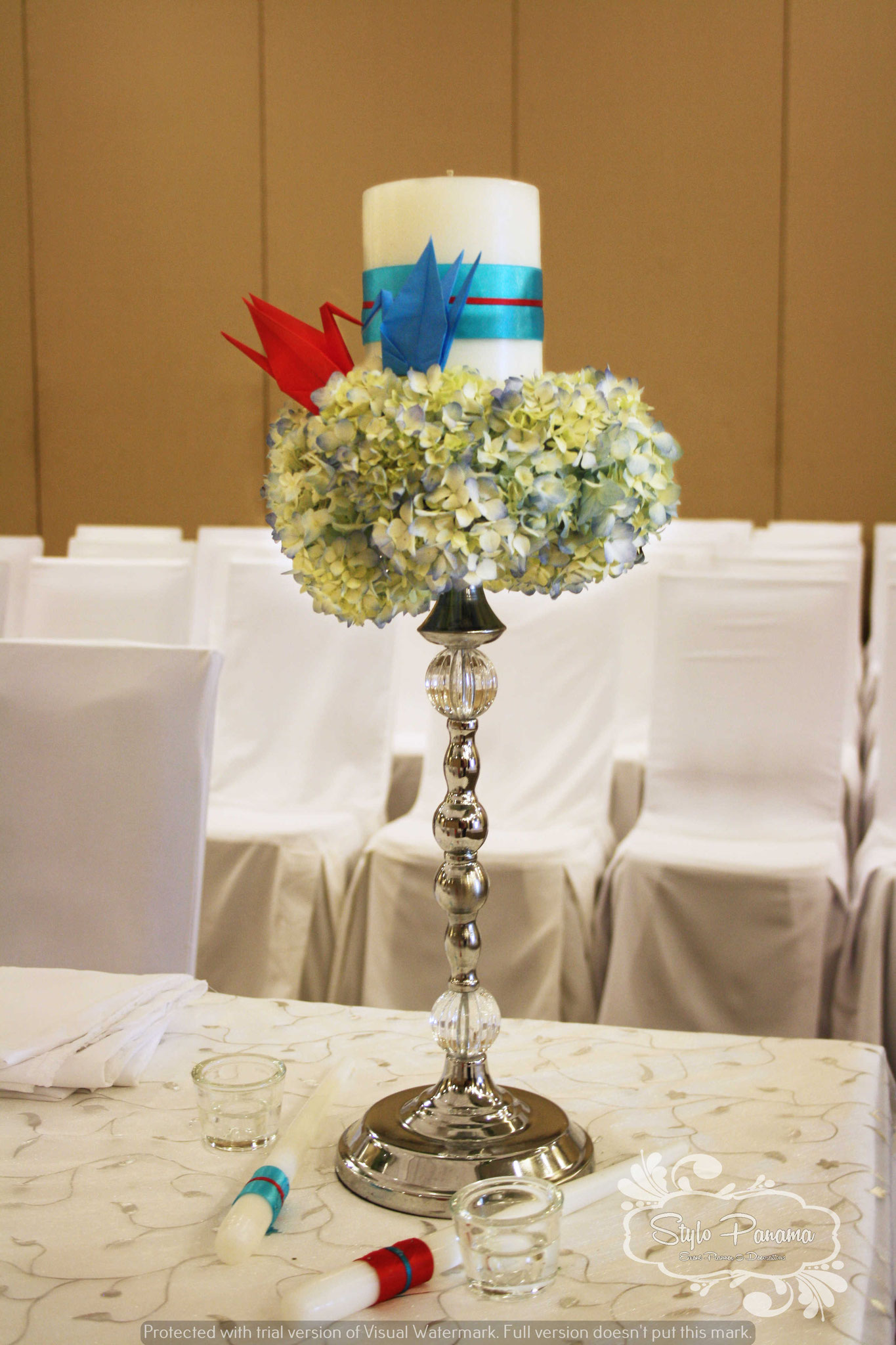 Vela central decorada junto a las velas largas de cada uno de los novios
