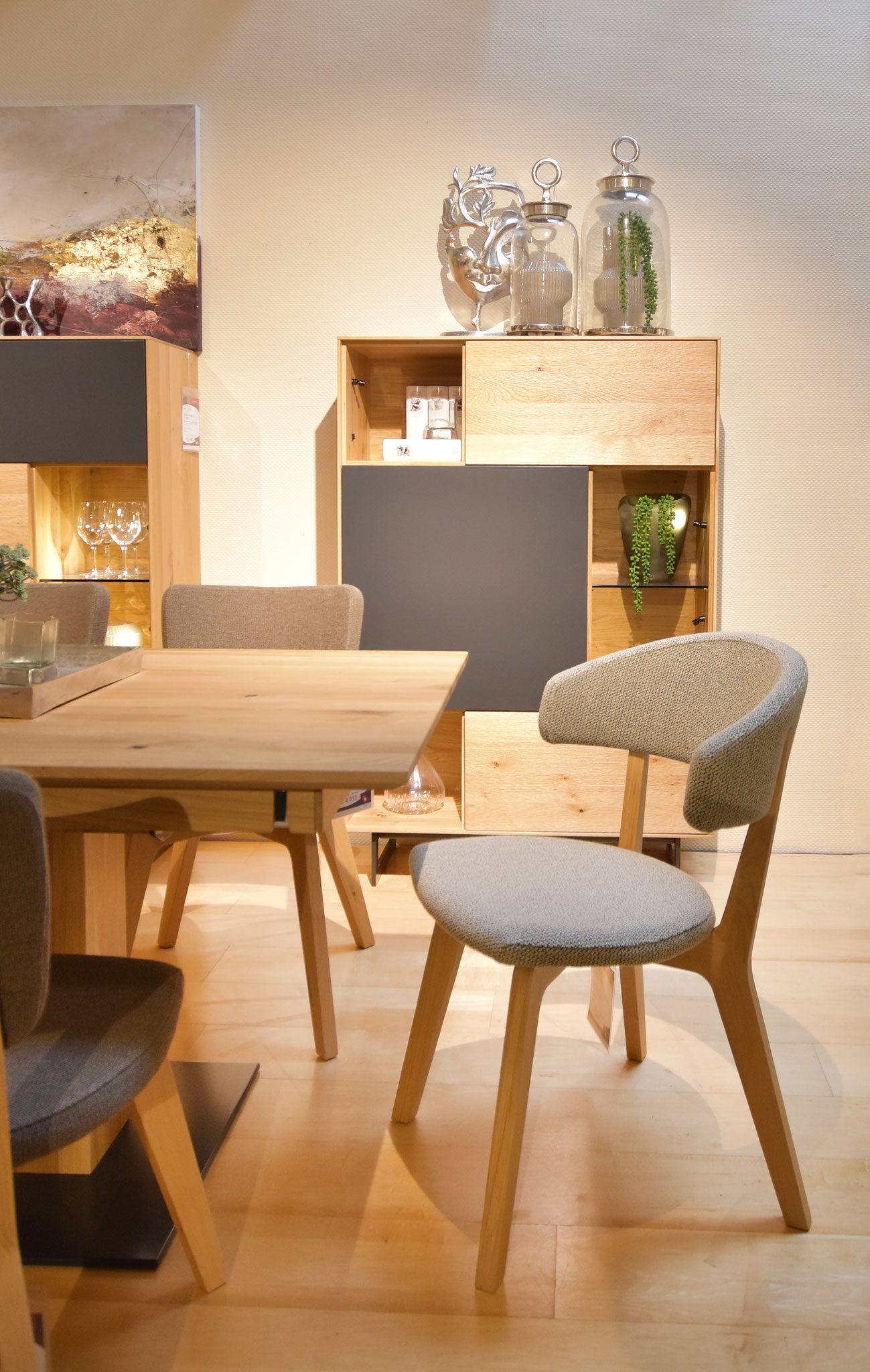 Esstischs aus hellem Holz mit modernen Stühlen und einem Sideboard im Hintergrund.