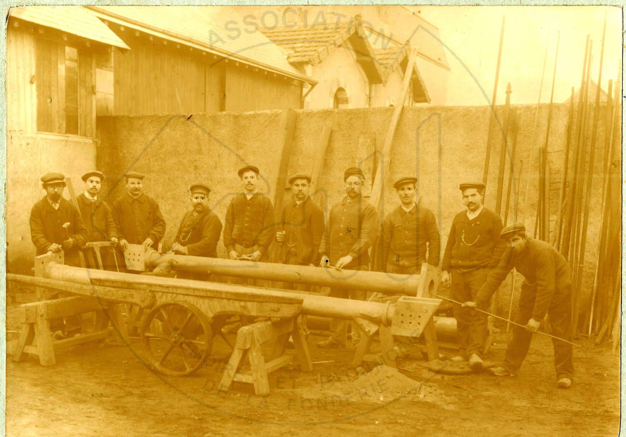 Une brigade de fondeurs devant des pièces élancées et complexes sortant de la fonderie vers 1910.