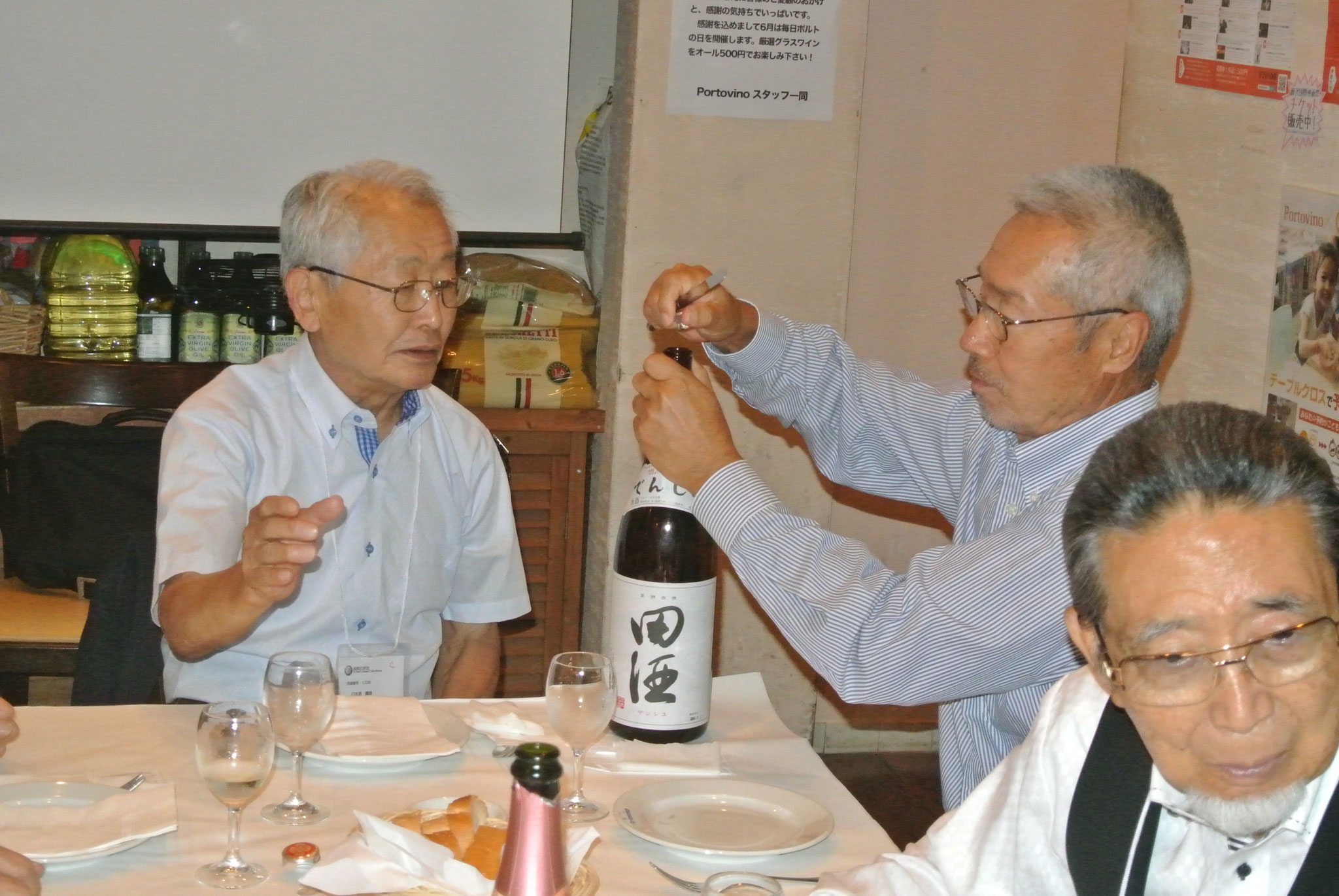 和田名誉利き酒師の前で小林副会長名酒田酒を開ける右岸野講師