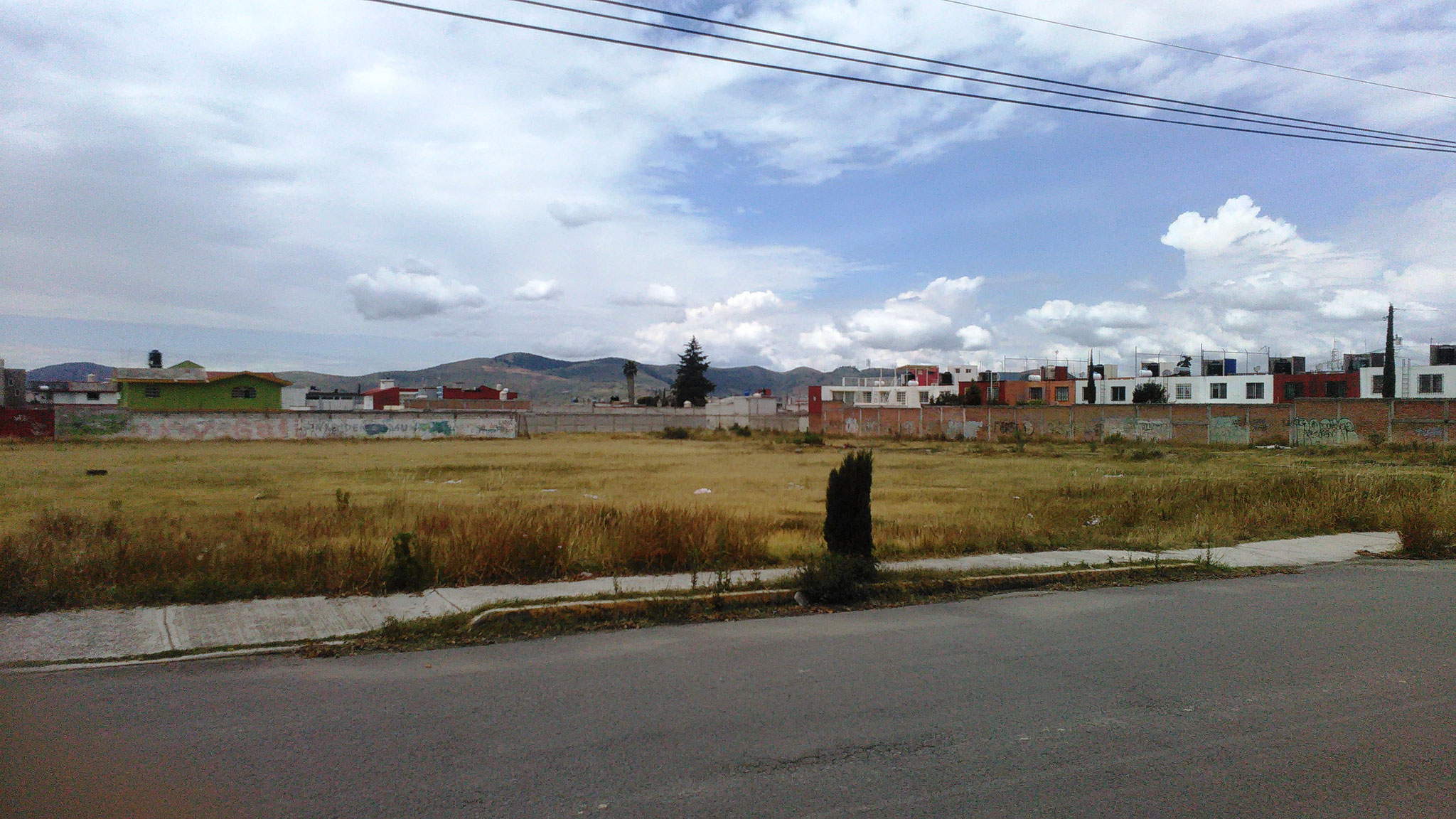 Vista del frente del terreno en venta en Castillotla desde la banqueta de en frente de la calle Santa Rosa