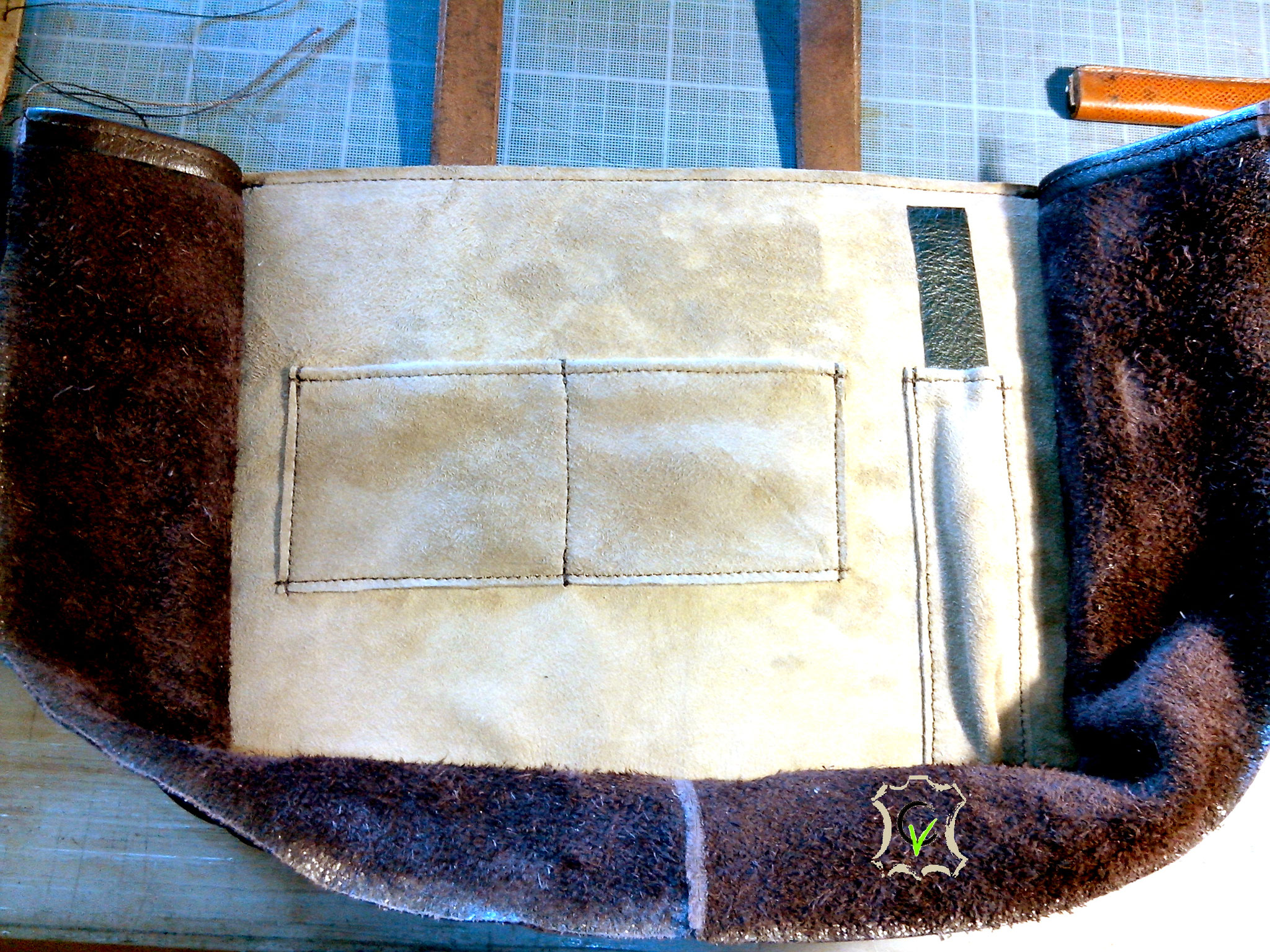 sac à main en cuir tannage végétal teinté brun avec motif par martelage doublure en mouton velours beige en cours de montage