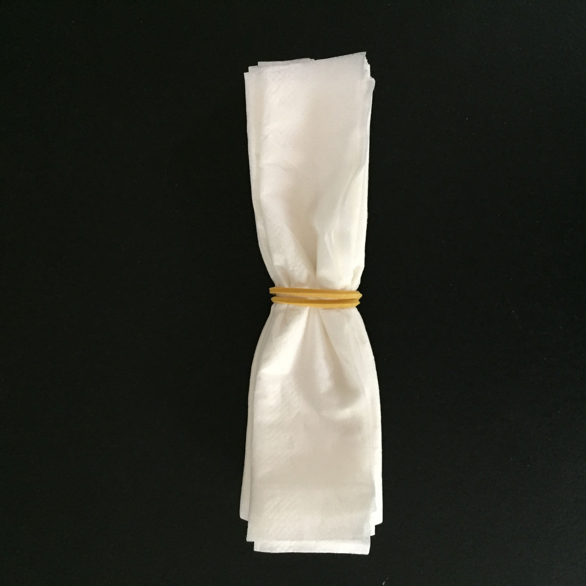 Du wickelst  das Gummi -Band drum herum. Schön in der Mitte.