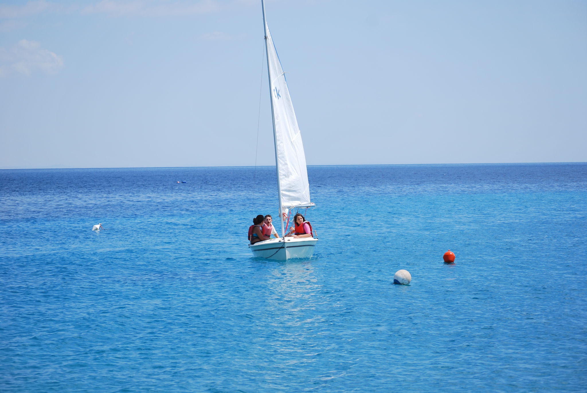 Bambini che imparano a timonare durante il corso di vela estivo a Soverato, Calabria