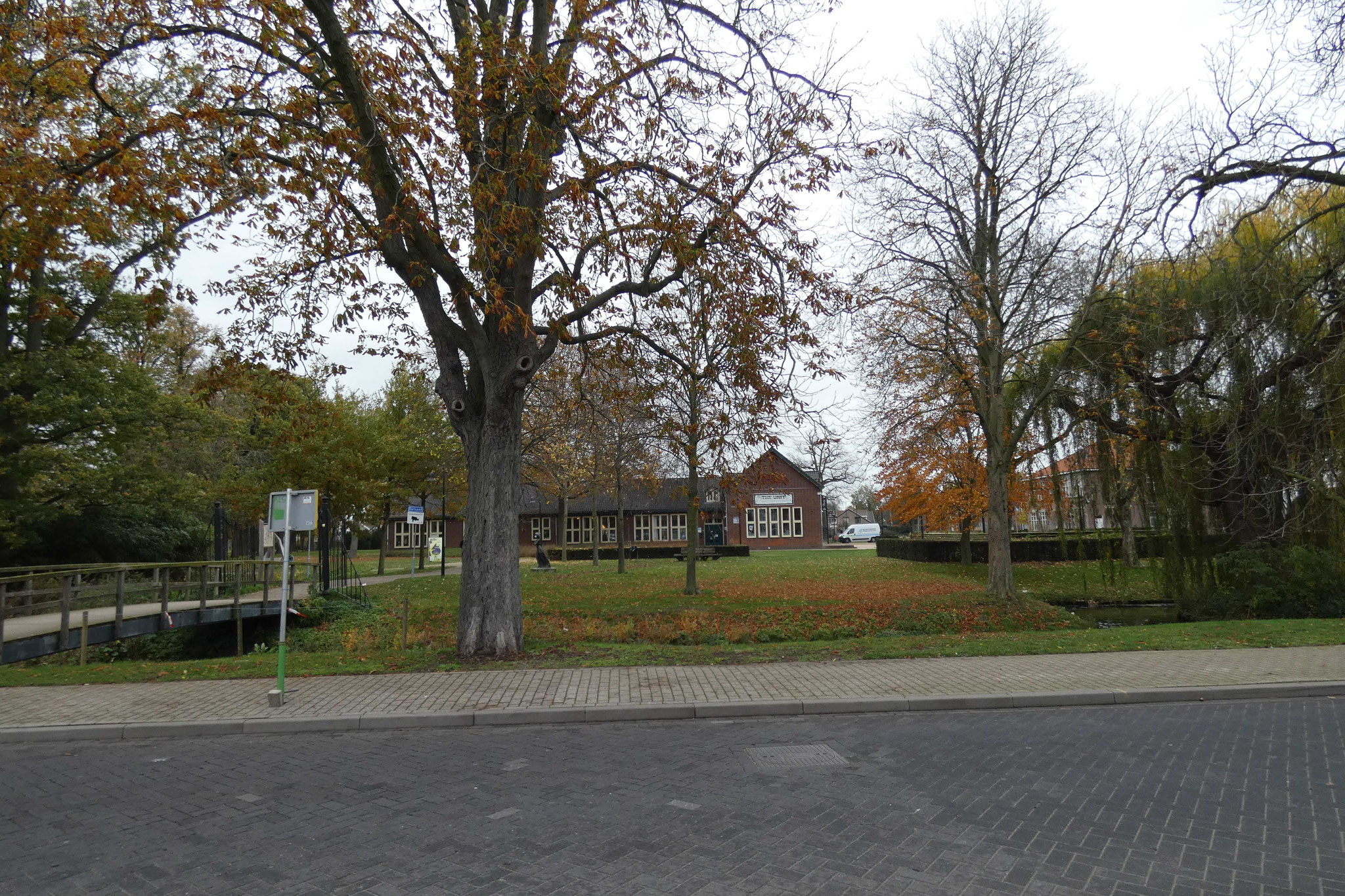 Zicht op het park vanaf de De Raetsingel. Vóór het rond 1940 gebouwde schoolgebouw, stond het oude herenhuis De Elzendonck.