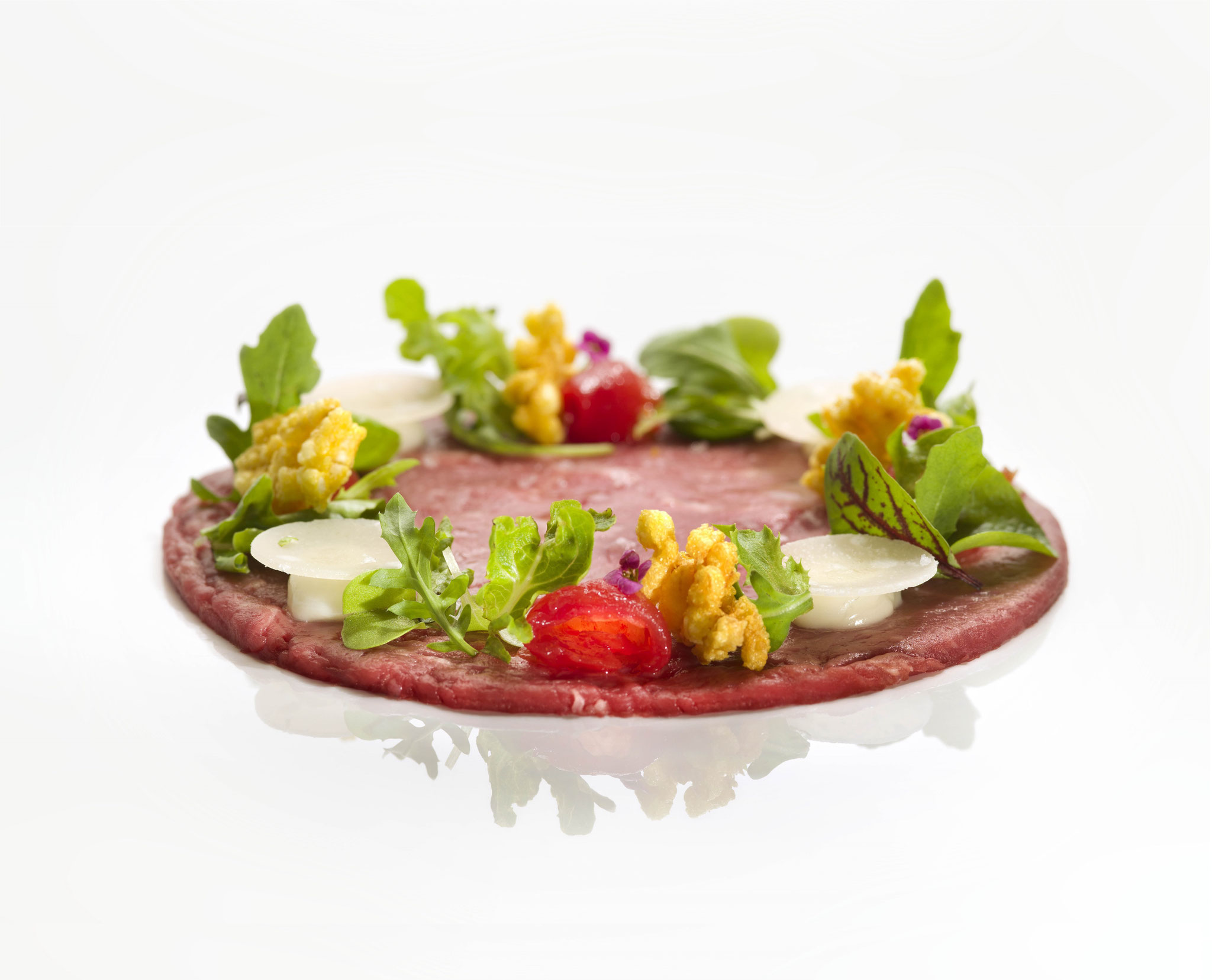 Carpaccio - viande de boeuf crue, additionnée d'huile d'olive, parmesan et crudités