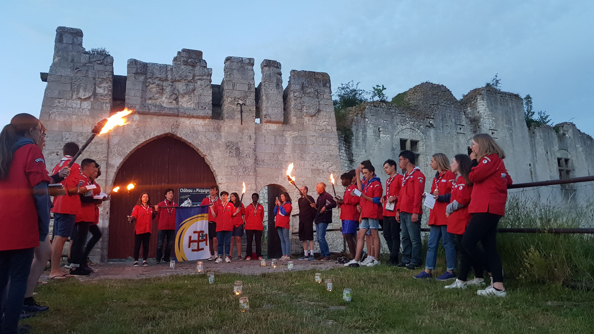 Cérémonie de promesse scoute à la tombée du jour devant le château