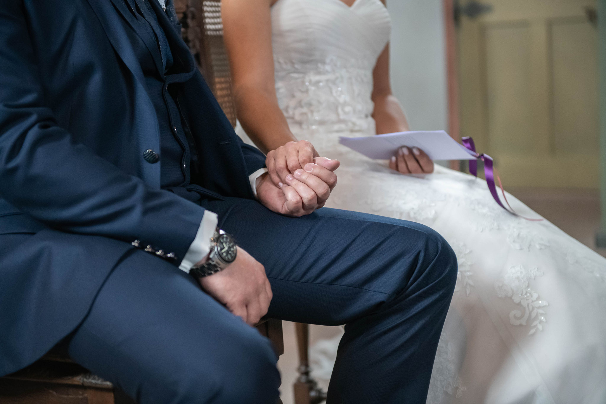 Braut und Bräutigam halten sich fest die Hände zusammen