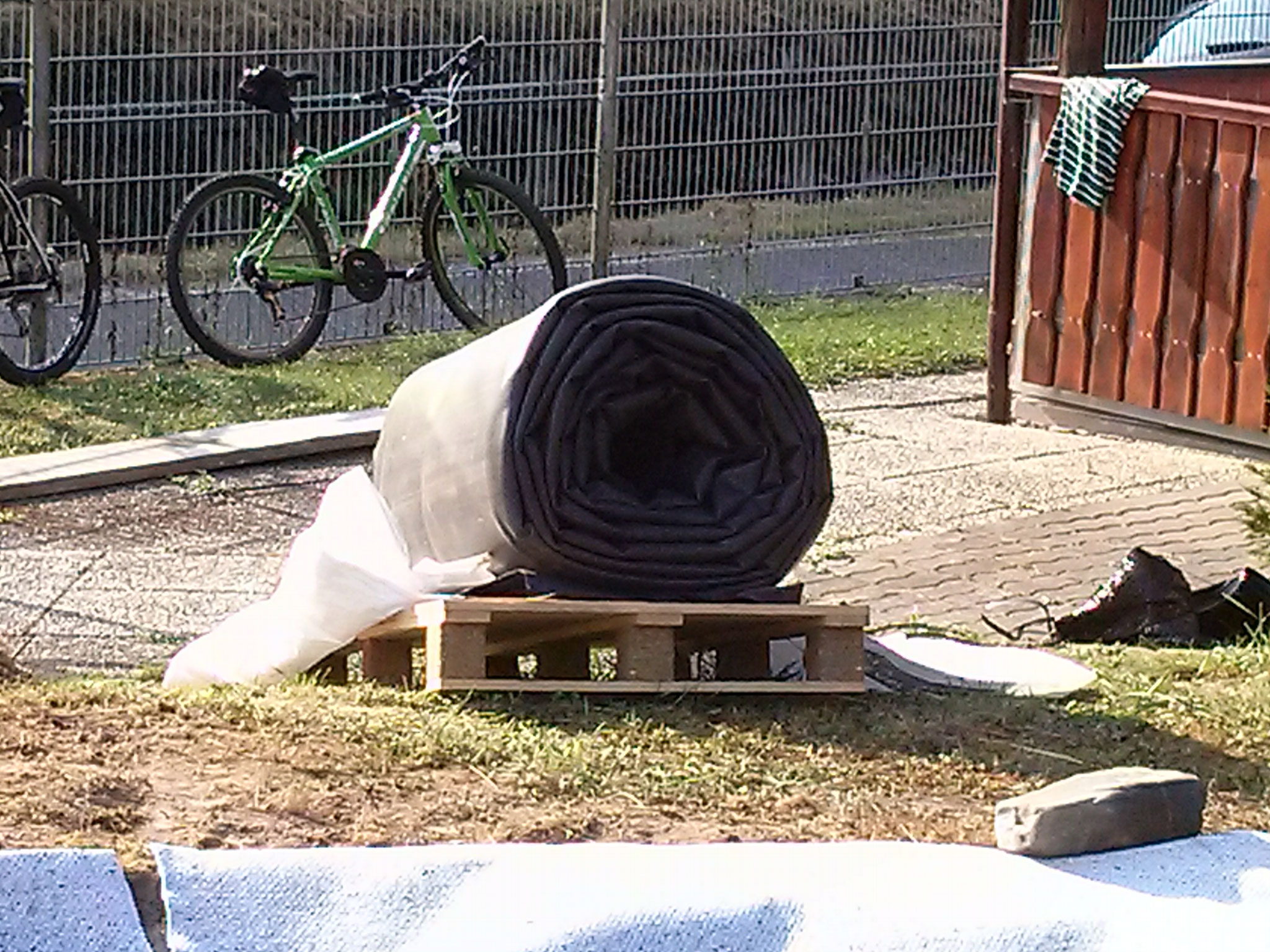 Nun ist die Zeit gekommen, die Folie wird ausgerollt und über den neuen Teich gelegt.