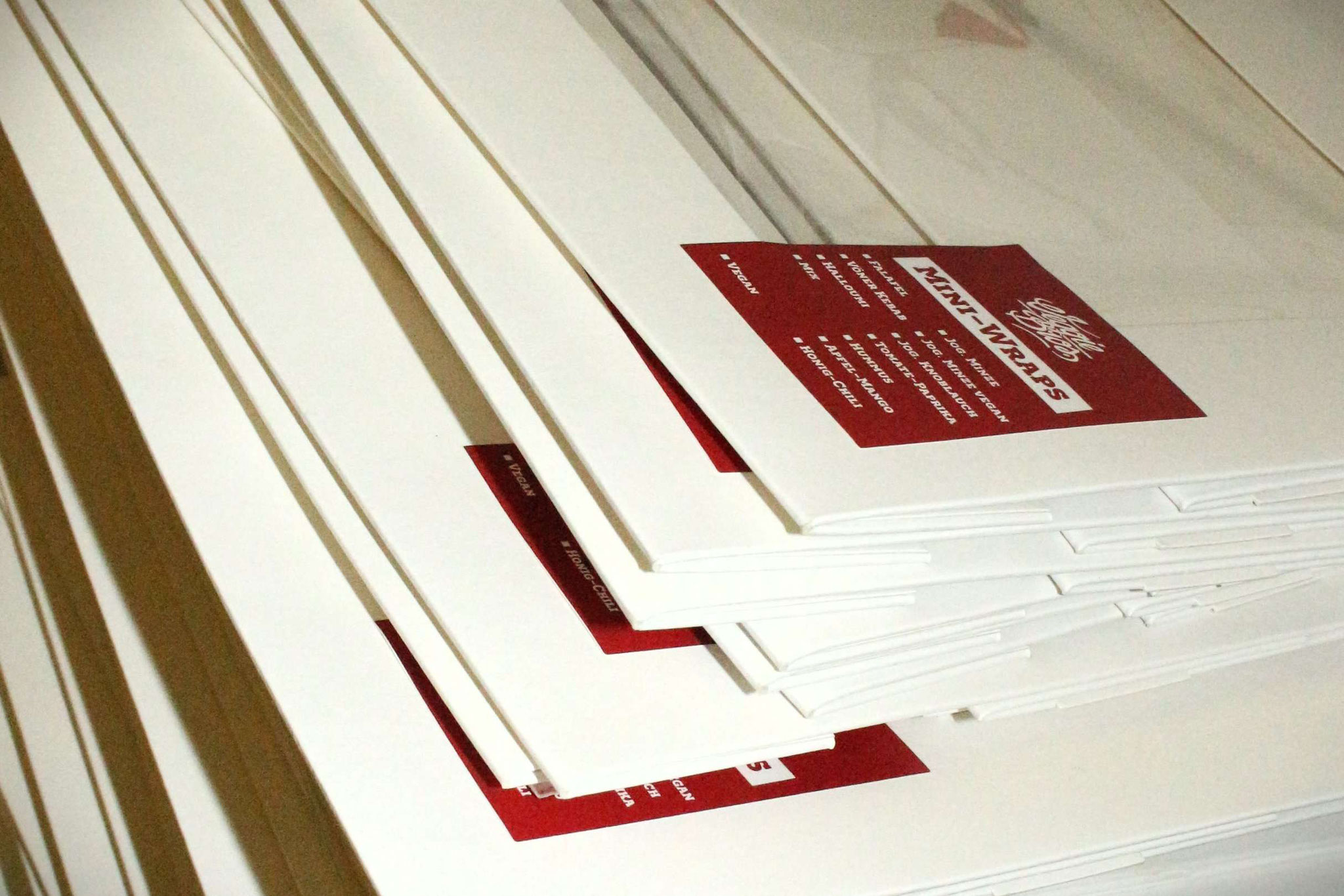 Unsere Mini-Wrap-Platten kommen in praktischen To Go-Verpackungen, serviert auf nachhaltigen Palmblatt Tabletts