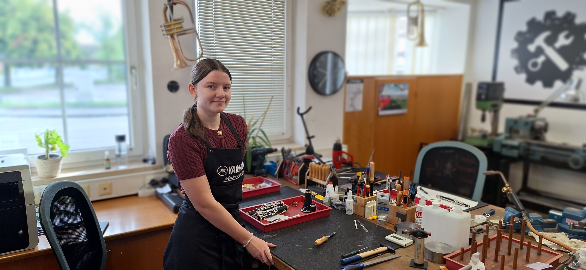 Werkstattmitarbeiterin bei der Reparatur eines Holzblasinstruments.