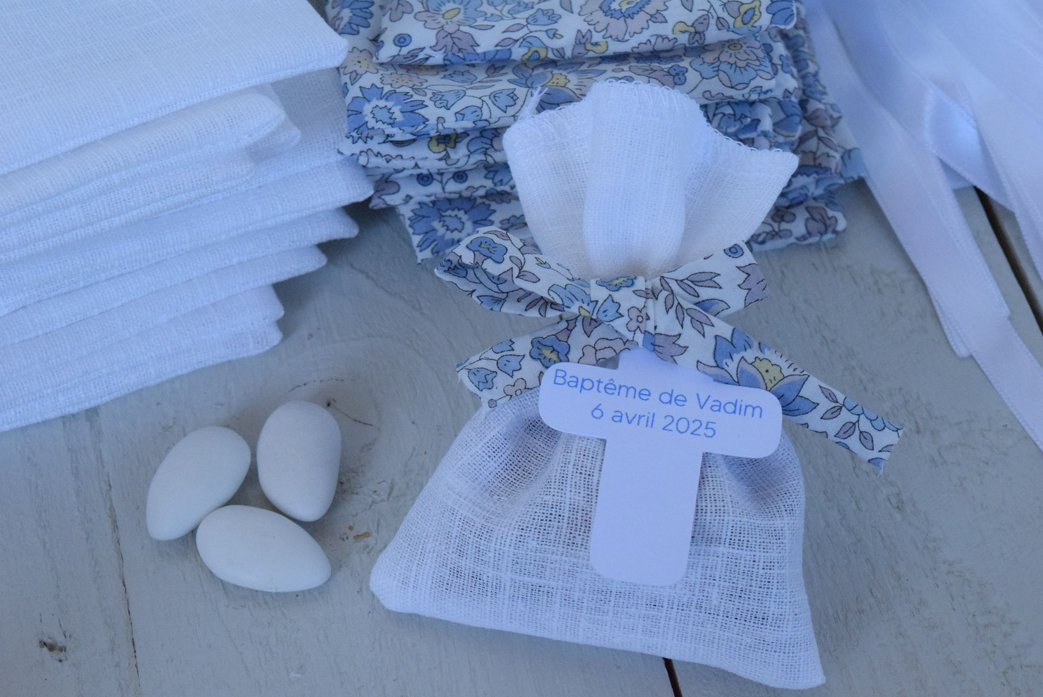 Sachet pochon dragées réalisé en tissu lin ou liberty of London bleu-gris avec broderie ou étiquette "croix" imprimée