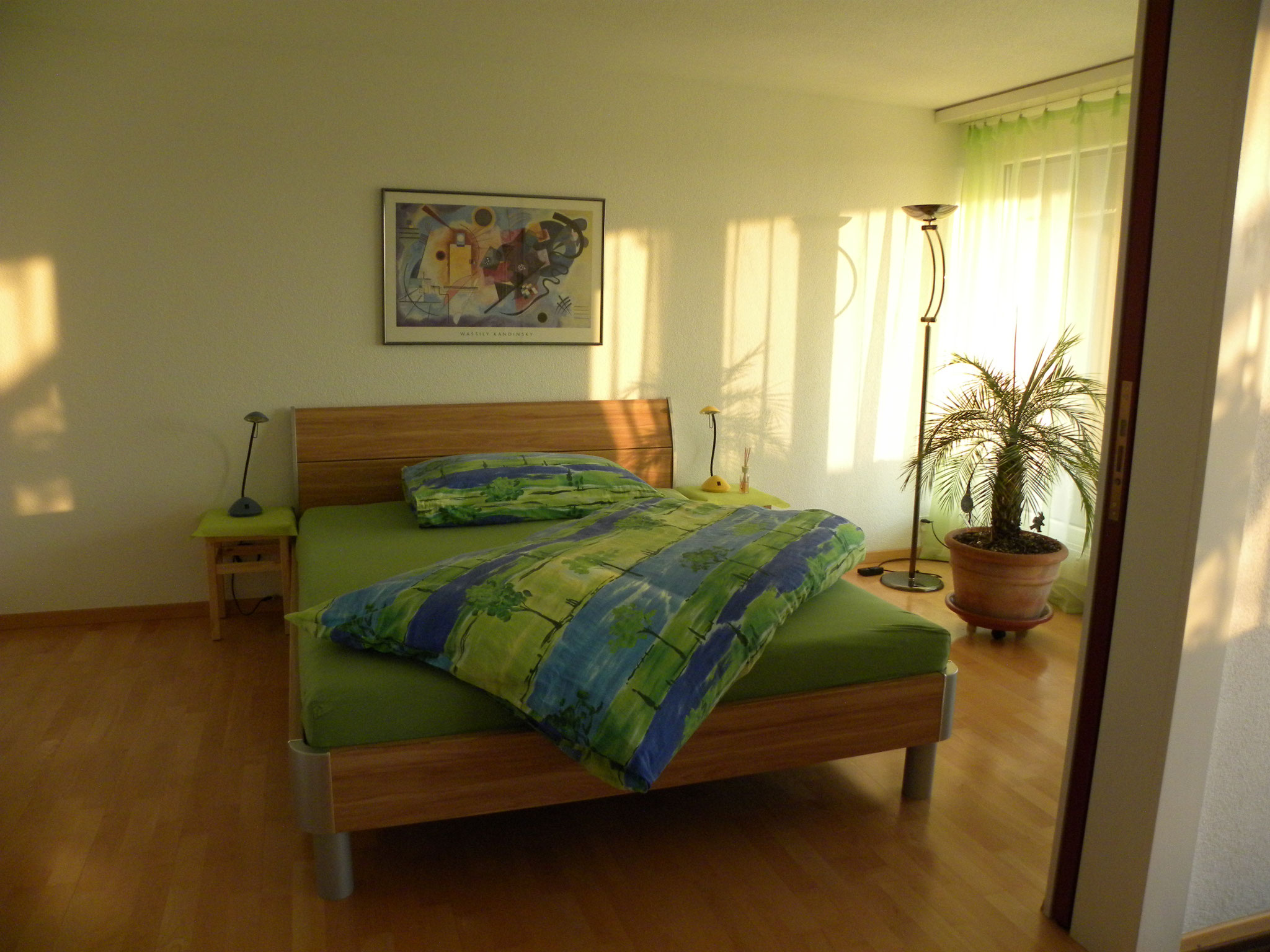 Light-flooded bedroom with double bed