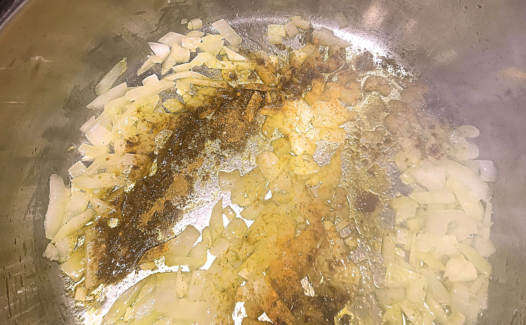 Zwiebeln, Knoblauch hacken, mit Gewürzen in Öl andünsten