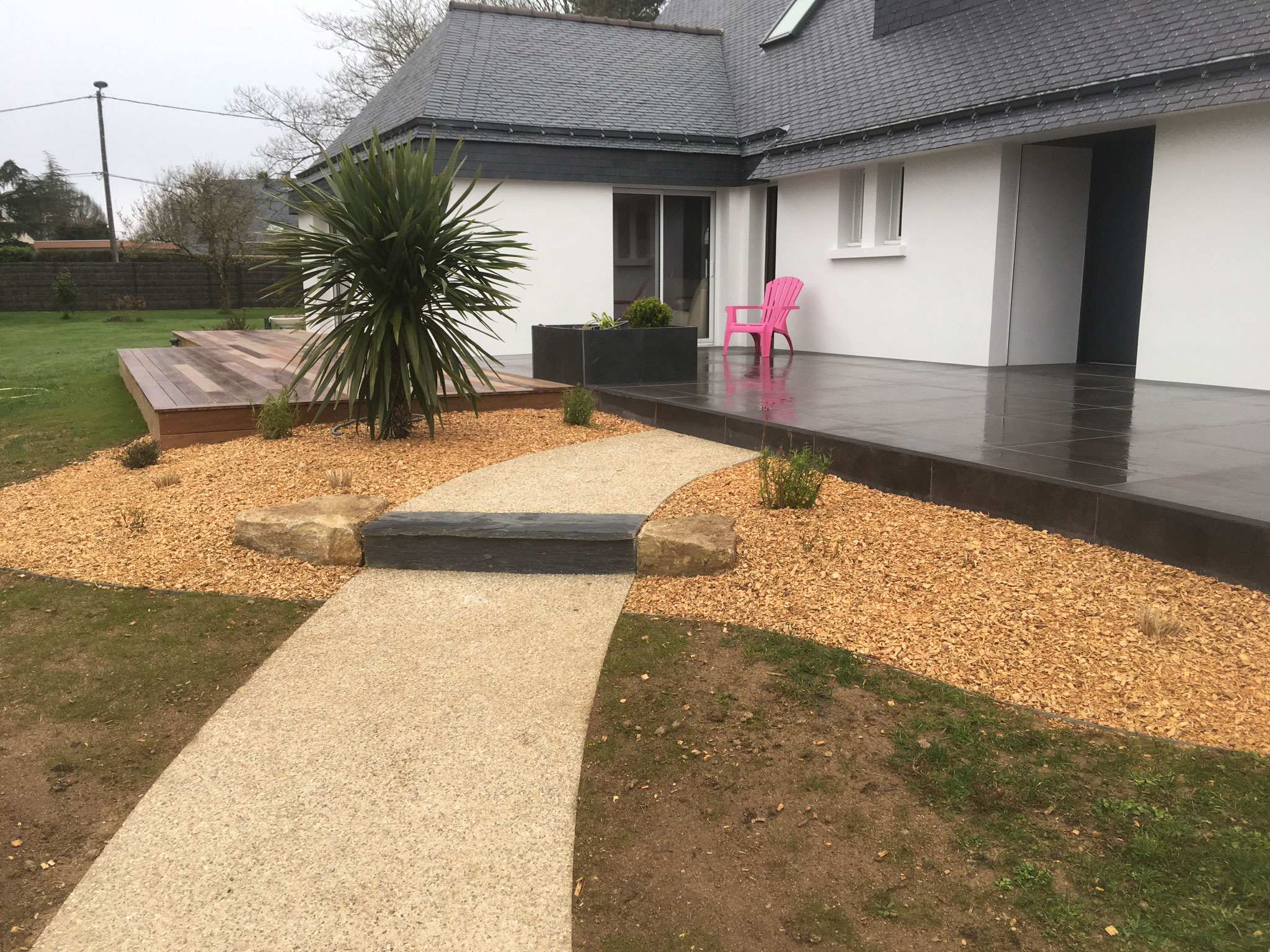 Aménagement d'entrée: béton désactivé, plantations, terrasse bois et dallage sur plots