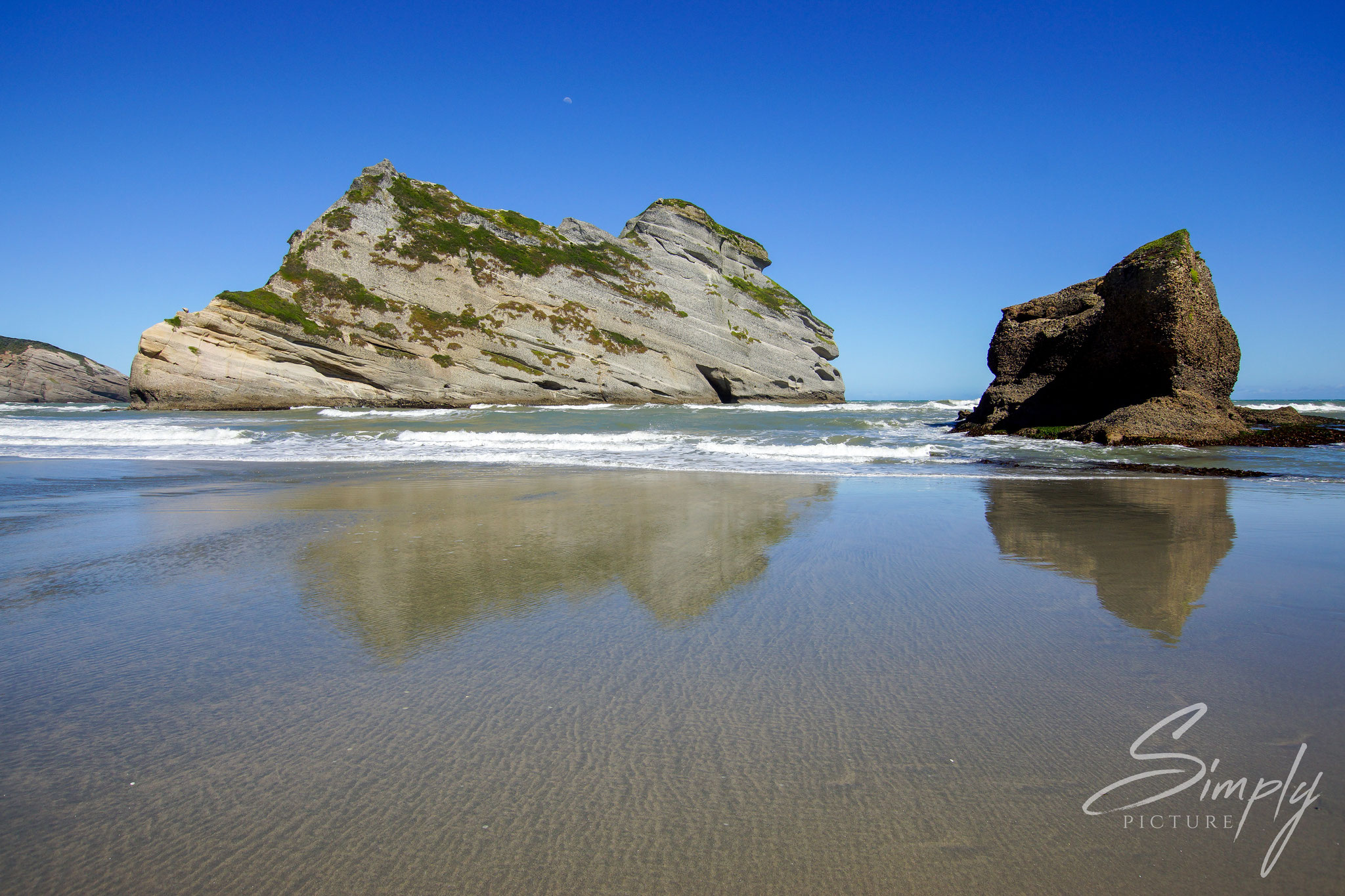 Puponga, Wharariki Beach, Strand mit einzelnen grossen Felsen im Meer