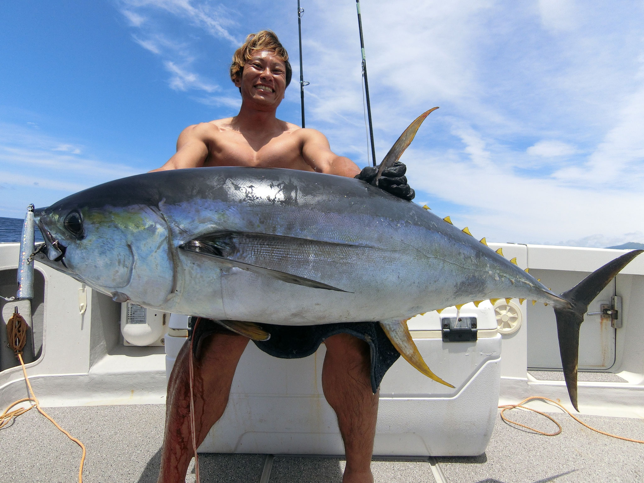 alt="Angler holding a massive tuna after catch in an intense offshore fishing scene"