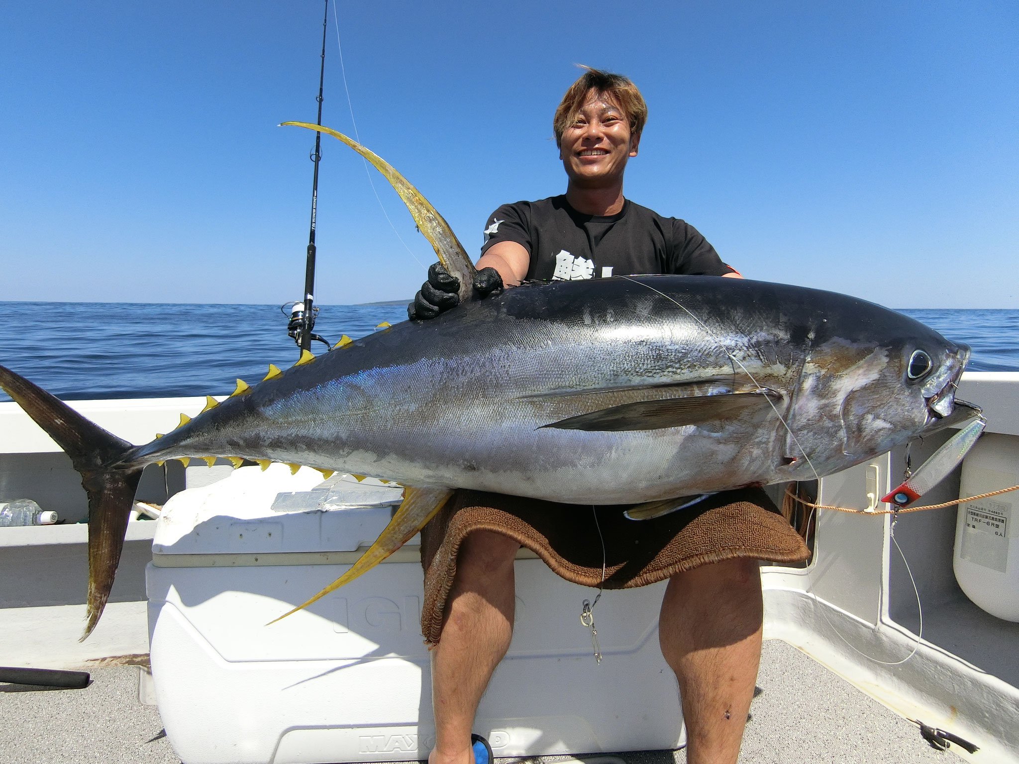 alt="Real offshore fishing scene with angler holding a freshly caught giant tuna"