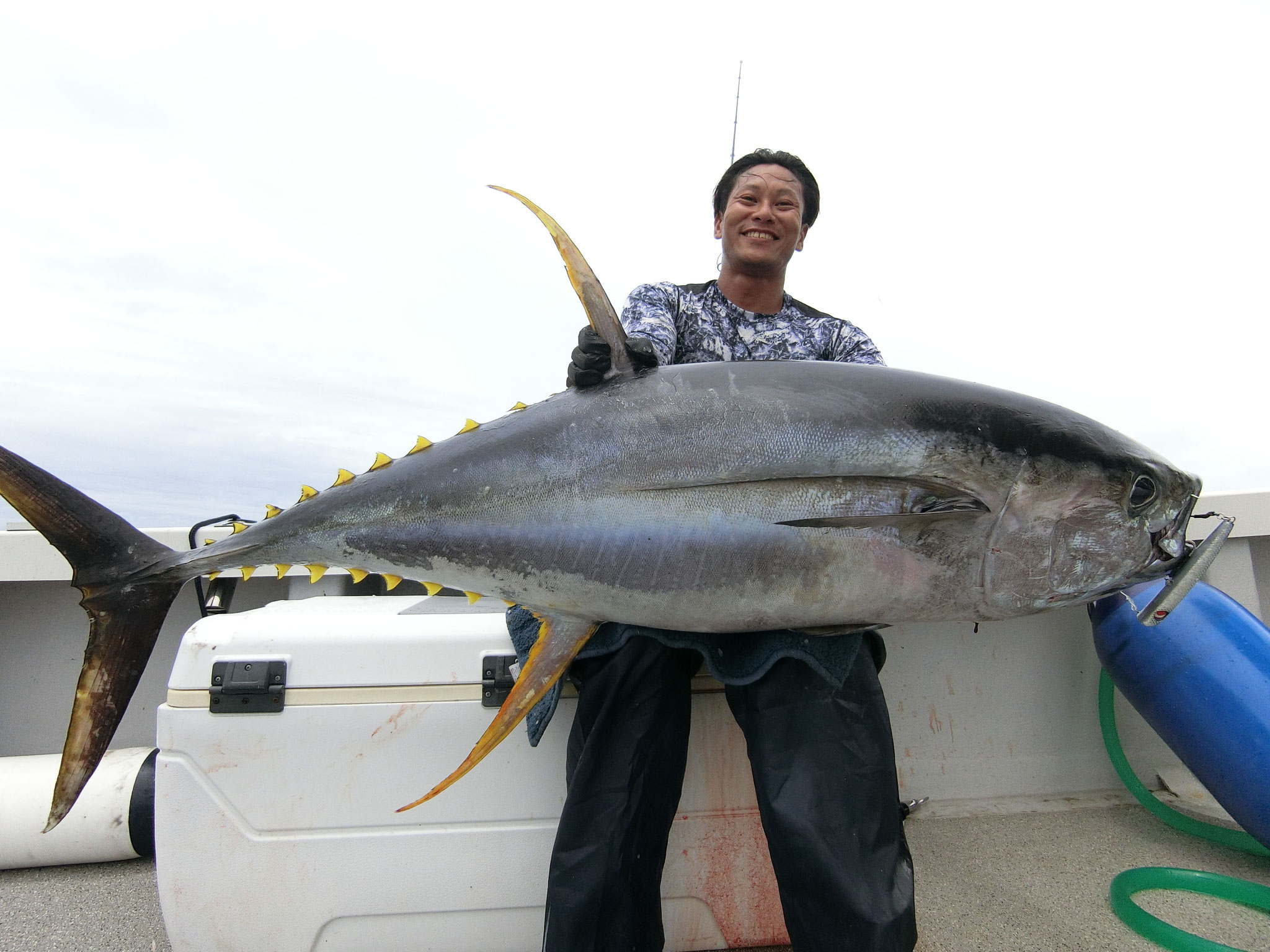 alt="Yuki Inoue holding a giant tuna after a hard offshore battle"