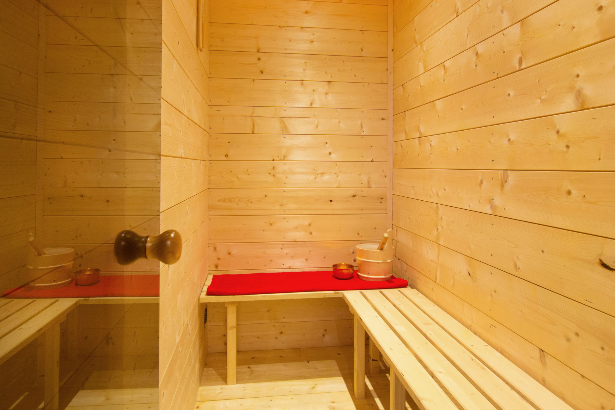 ferienhaus foto kleine sauna mit rotem handtuch und goldenem teelicht