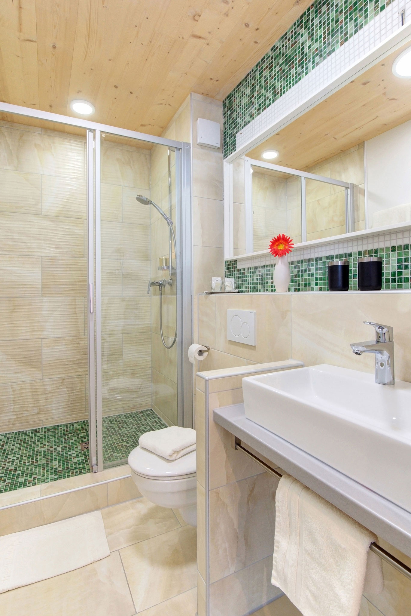 hotelfotograf badezimmer mit waschbecken und dusche eingerahmt mit tuerkisfarbenen kleinen Kacheln