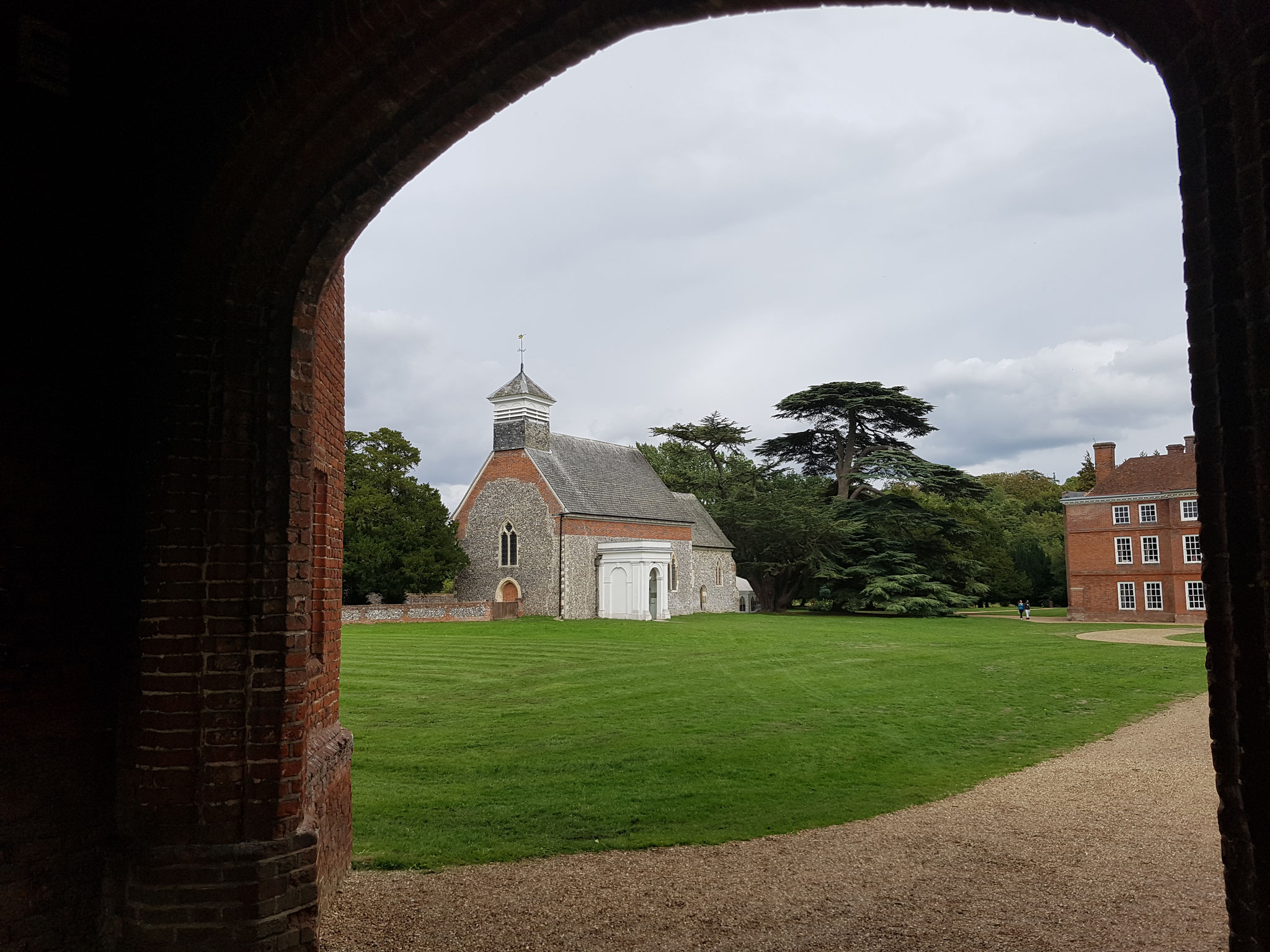 Exterior is restored Gothic with Decorated windows and an early 16th century side chapel. Th classical porch is 18th c.