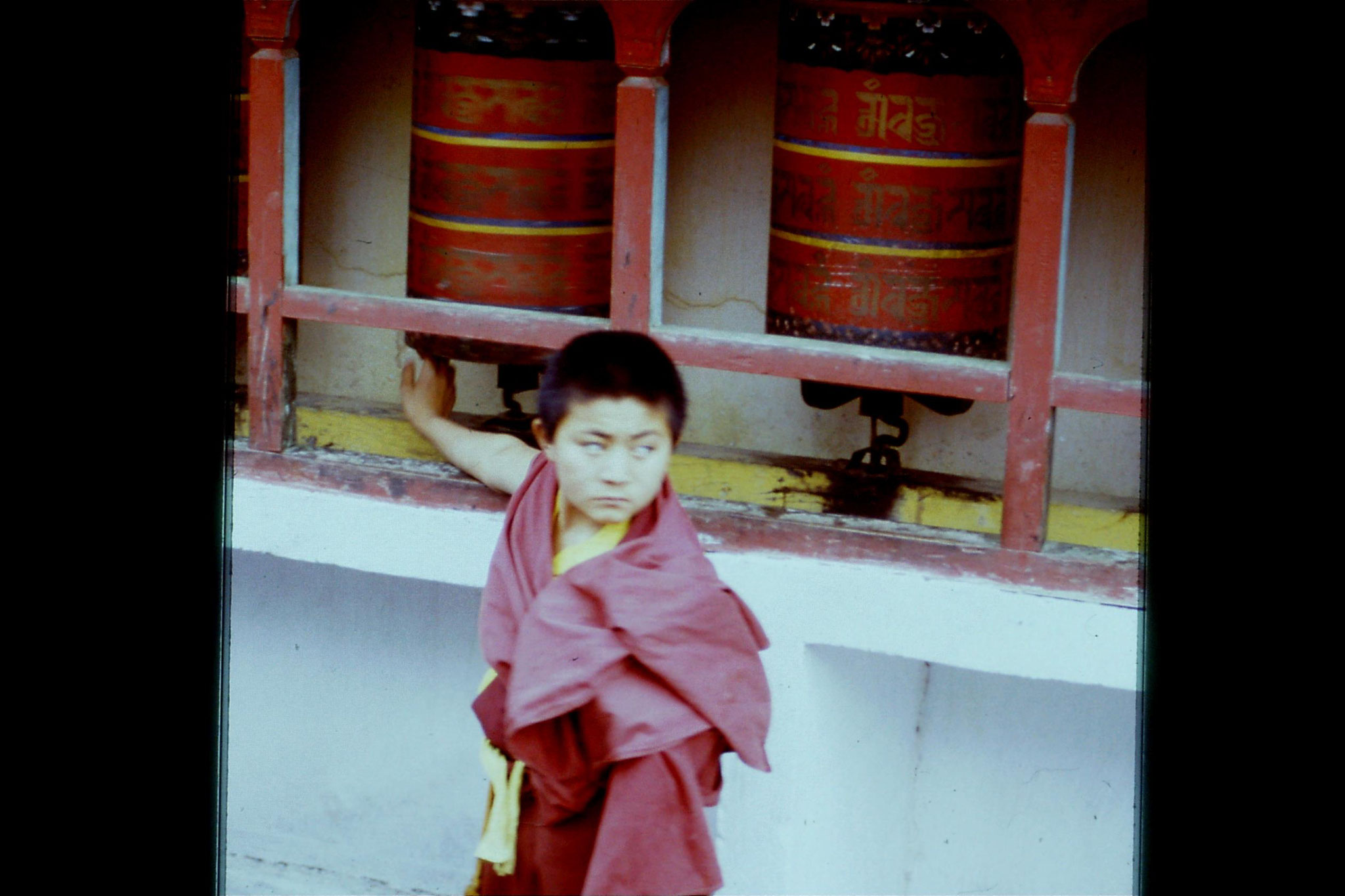 115/13: 23/4/1990 Rumtek - prayer wheel and boy monk