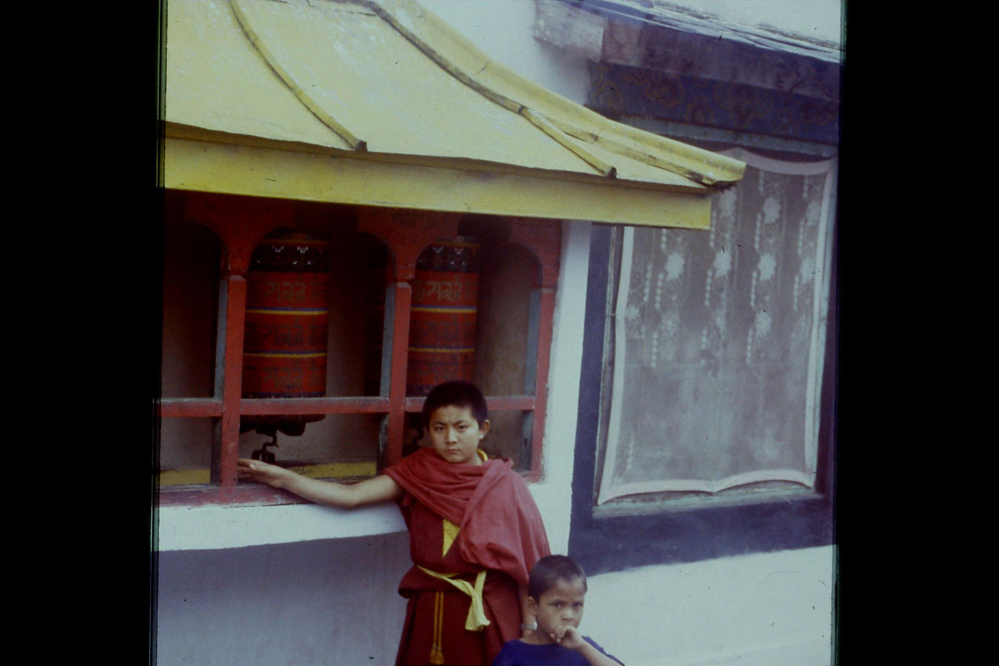 115/14: 23/4/1990 Rumtek - prayer wheel and boy monk