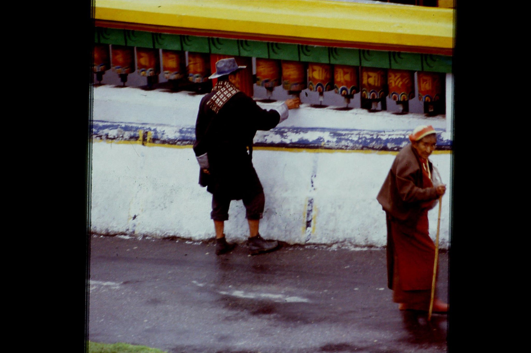 115/12: 23/4/1990 Rumtek - man turning prayer wheel