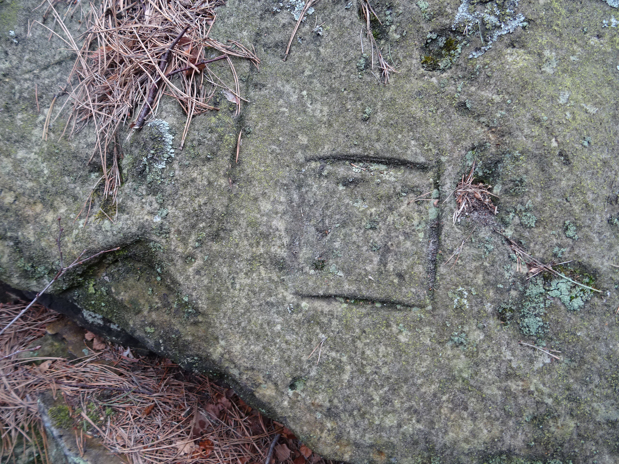 Am Felsen sind mehrere Quadrate, alte, heilige Symbole zu finden