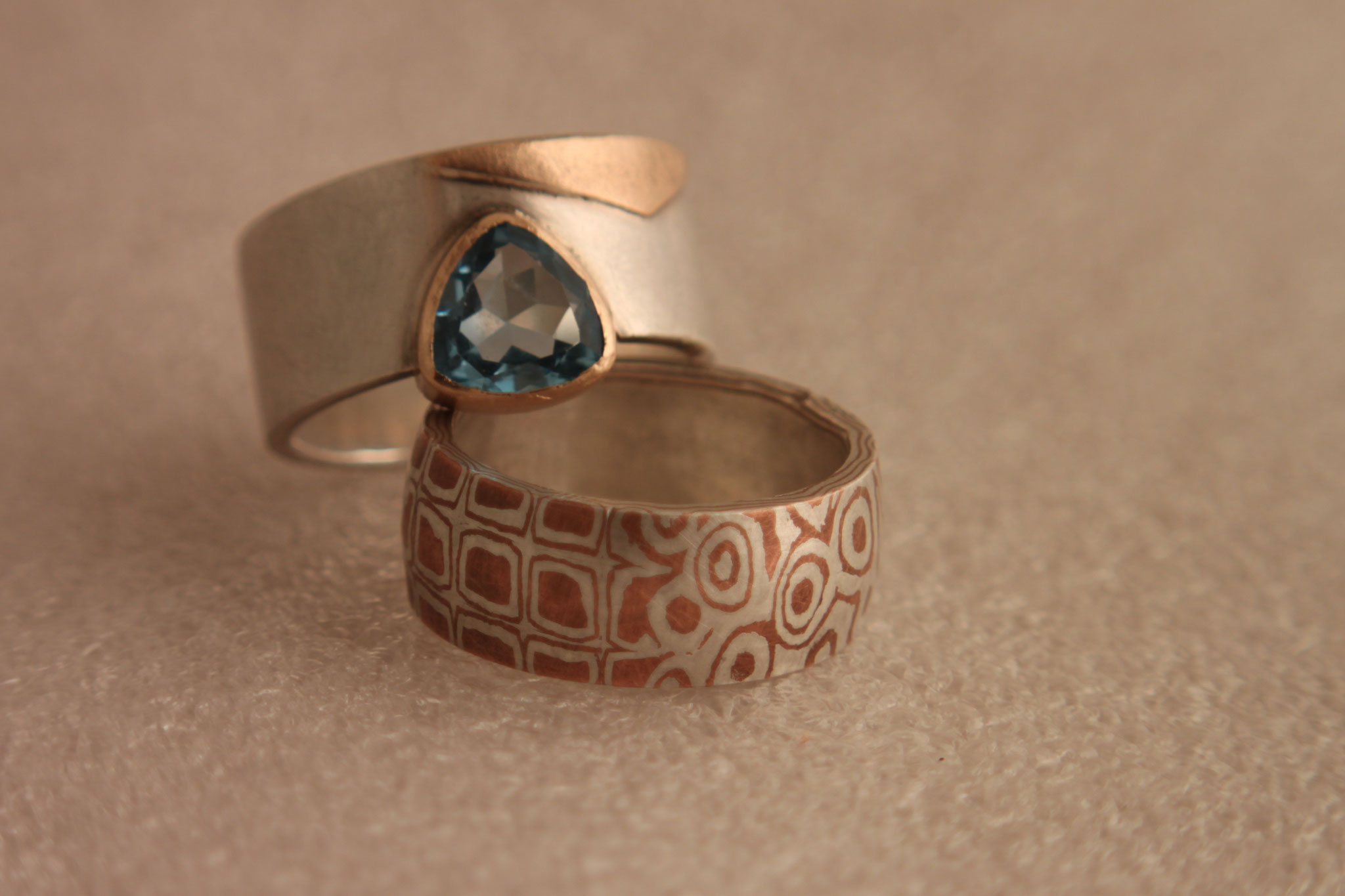 links: Ring aus 925/- Silber, 585/- Rosegold, mit Topas; rechts: Ring aus 925/- Silber und Kupfer