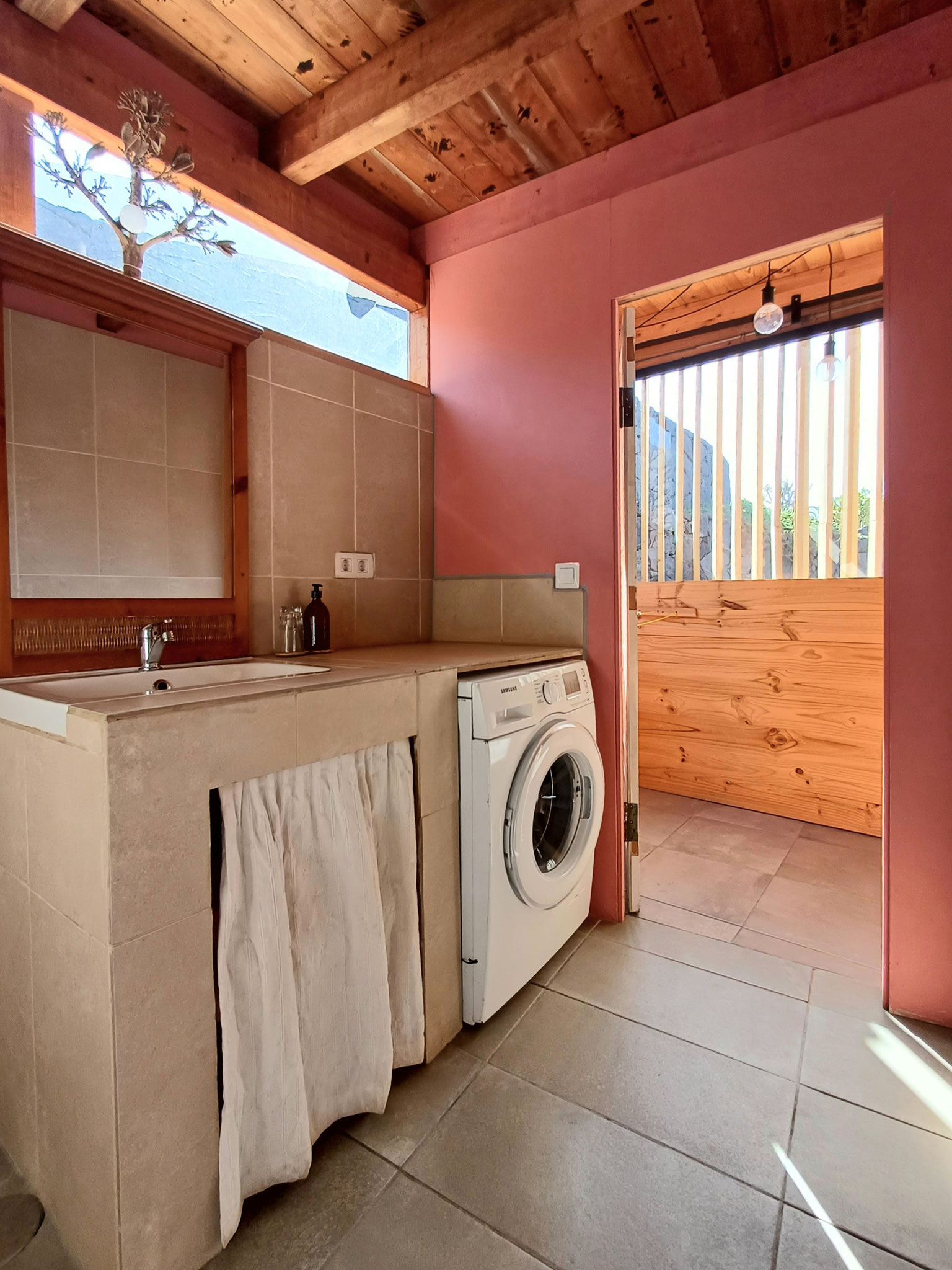 une salle de bain abrite la machine à laver