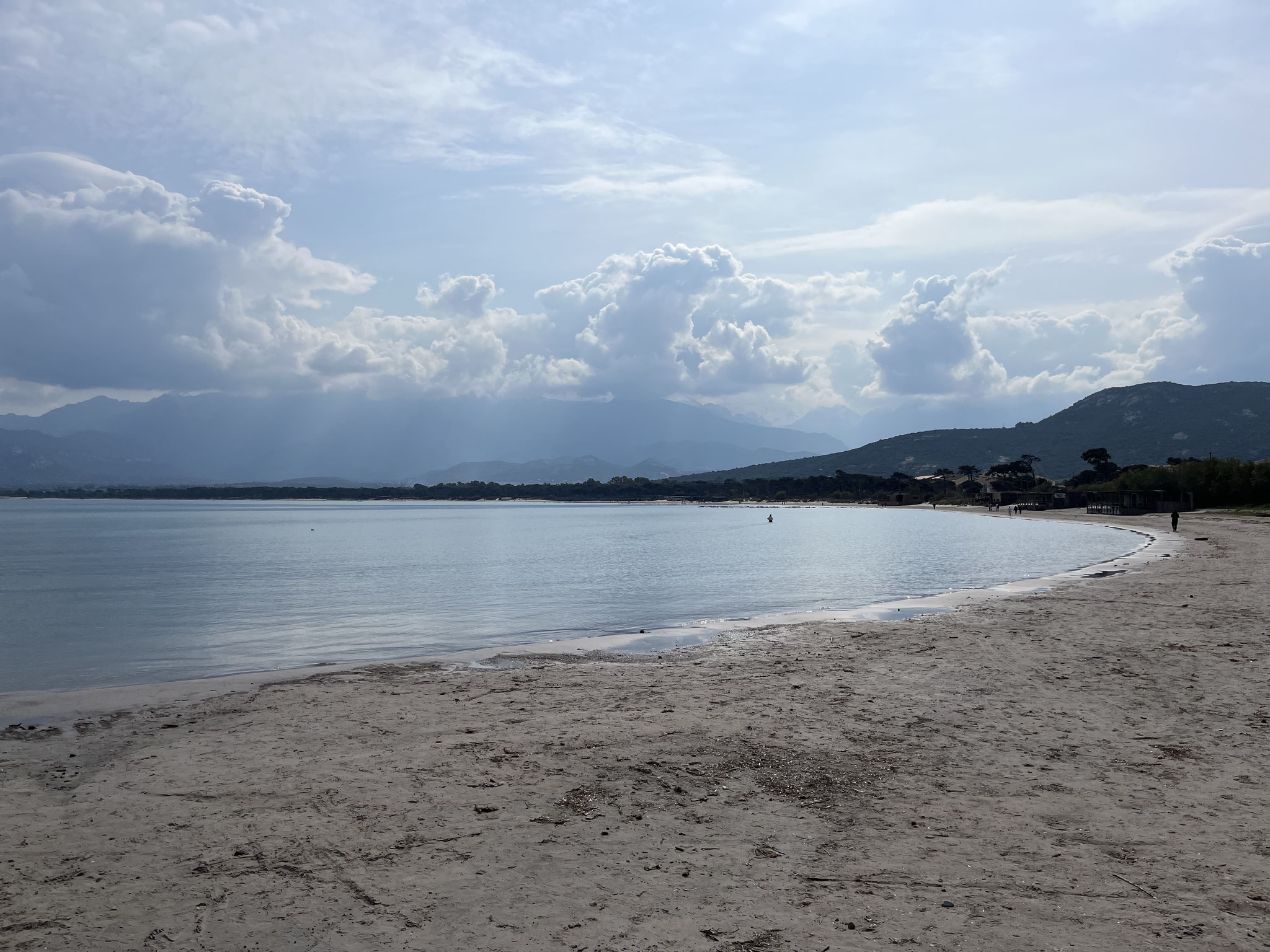 Ein breiter und langer Sandstrand mit dem Segelzentrum, befindet sich direkt neben dem Hafen.