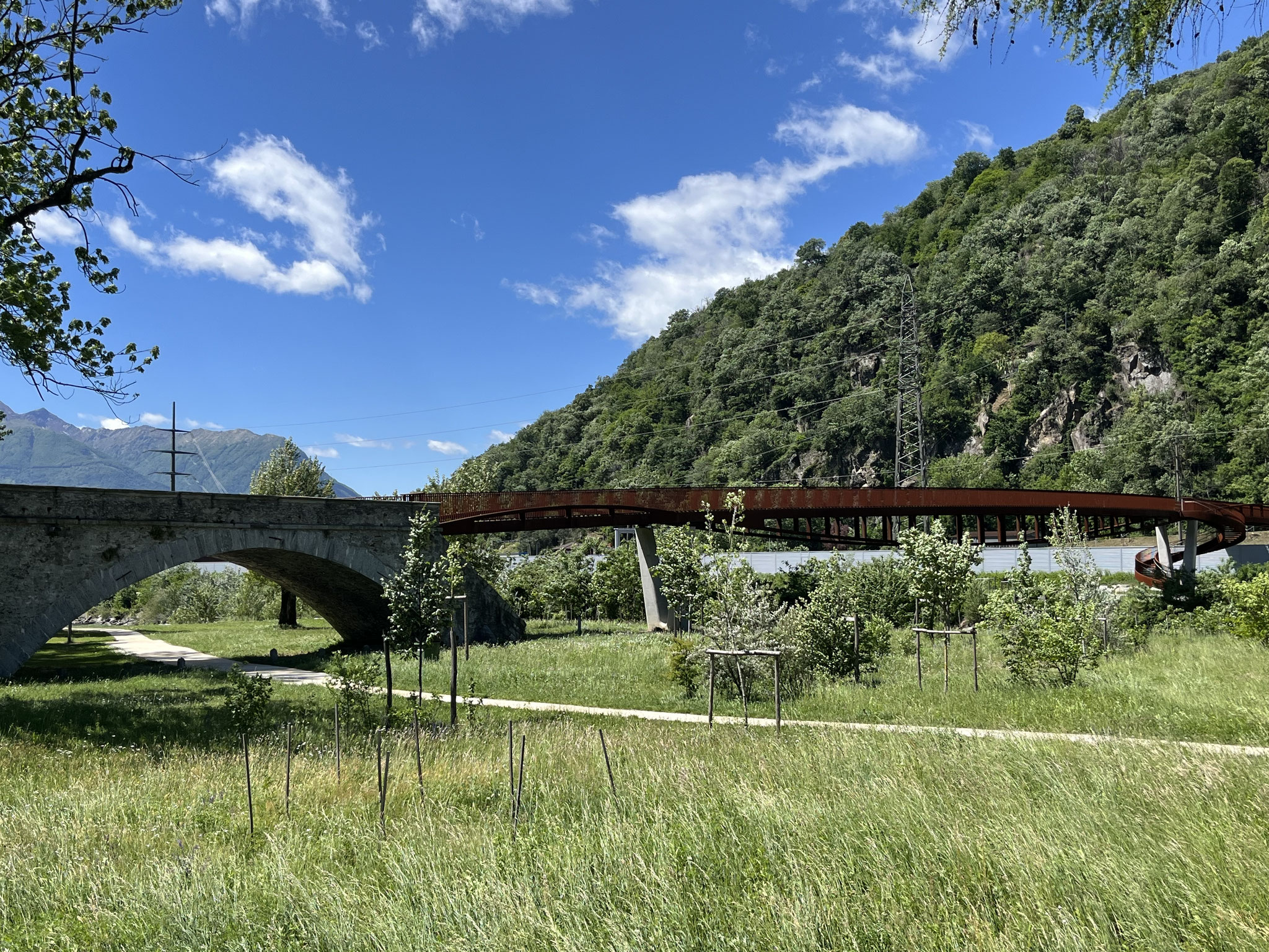 Wir bestaunen die elegante Edelrostbrücke, die aus der alten Steinbrücke „hervorgeht“ und sich über den Ticino schwingt.