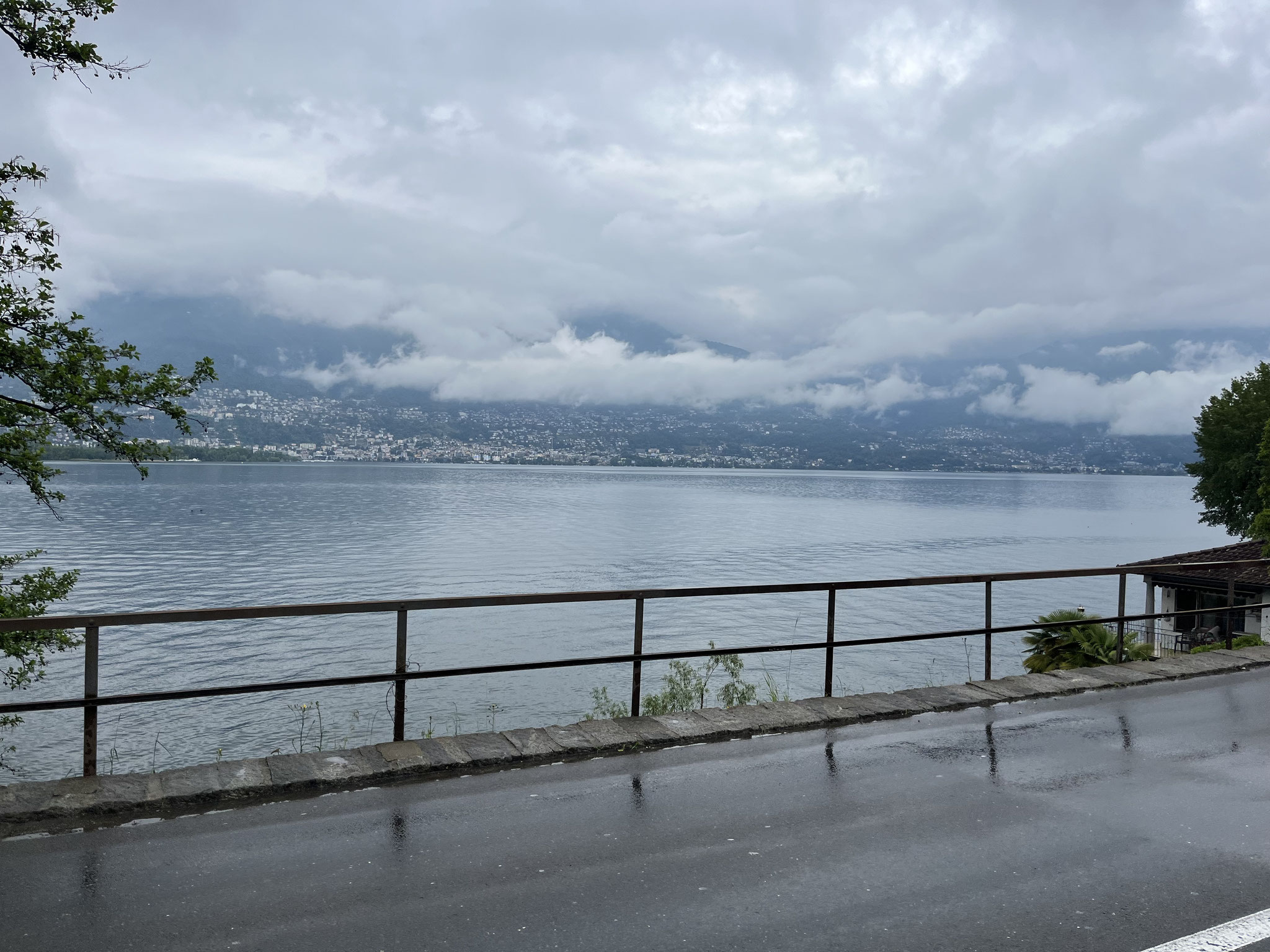 Die Wolken hängen tief und es regnet immer wieder. Auf der gegenüberliegenden Seeseite erblicken wir das Maggiadelta und Locarno.