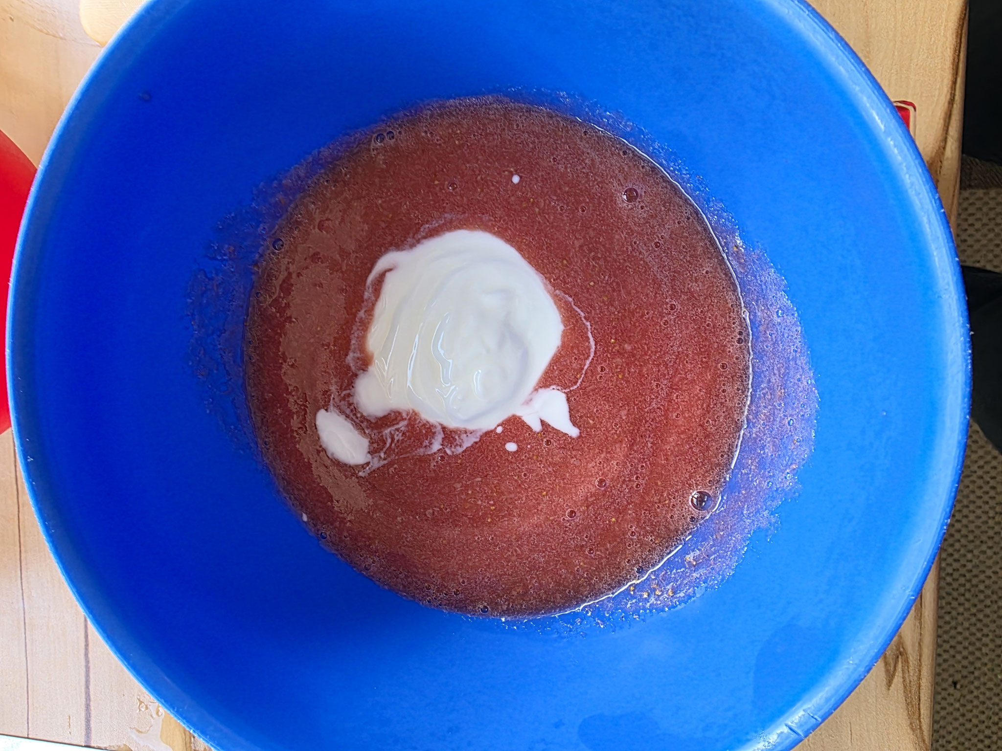 Yoghurt in der Erdbeermasse bereit zum verrühren.