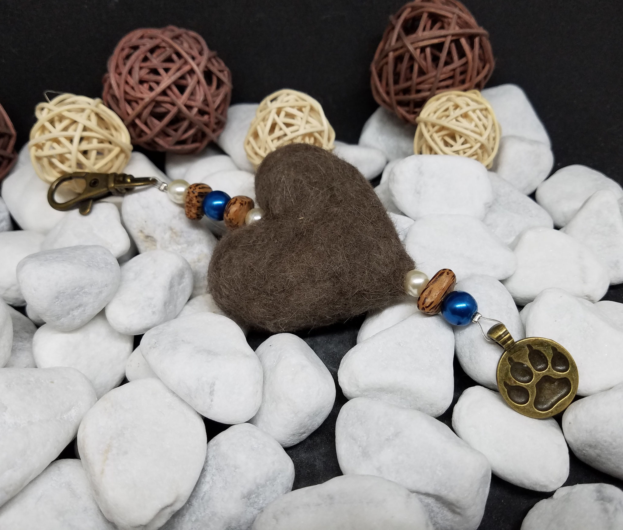 Anhänger "Großes Herz" aus einem gefilzten Herz aus Tierhaar, crémefarbenen und blauen Kunstperlen, dreieckigen Palmholzperlen und einem Anhänger "Pfotenabdruck bronze" - Preis: 34 Euro