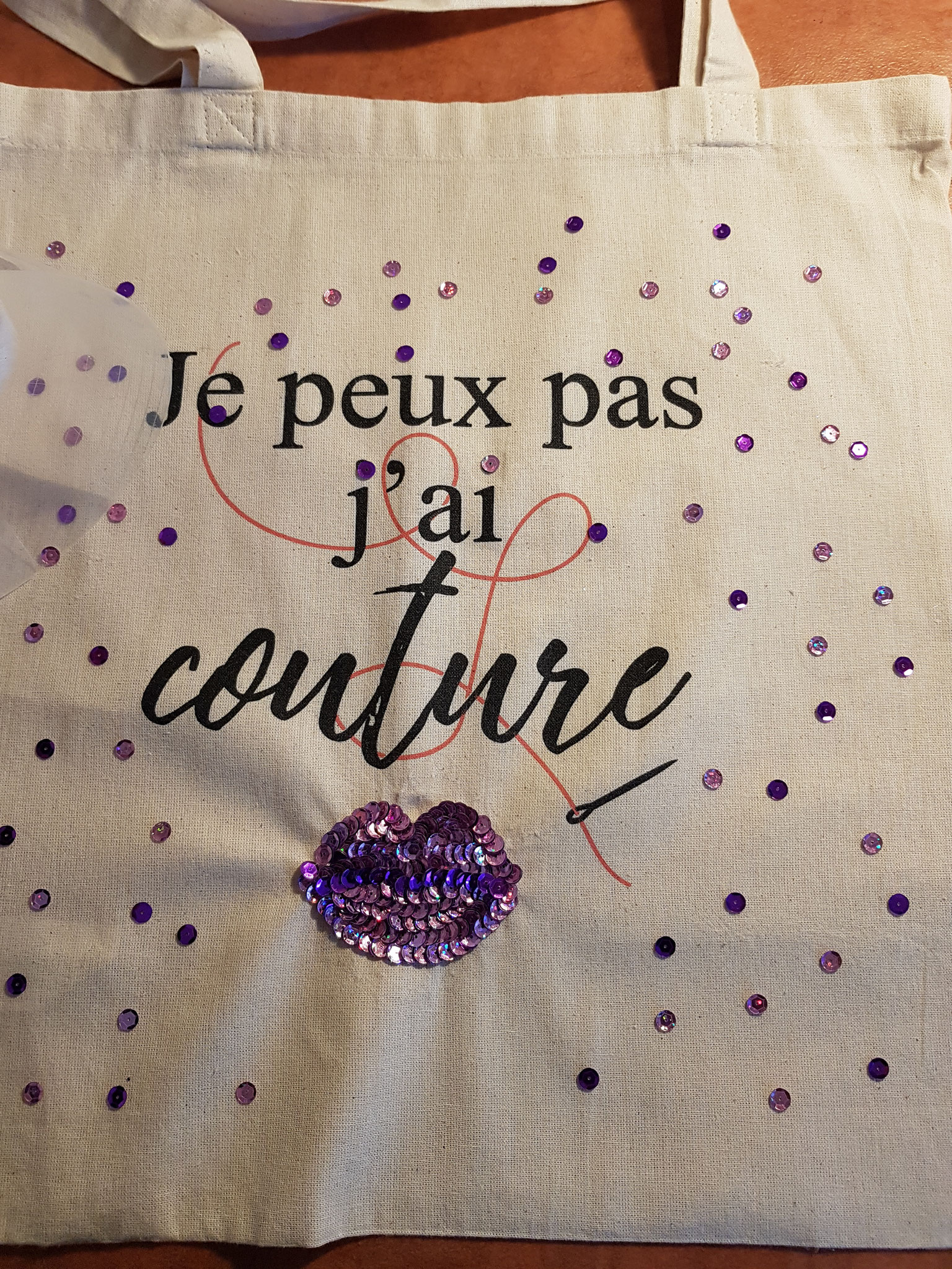 Pose de sequins personnalisés sur un tote bag du commerce