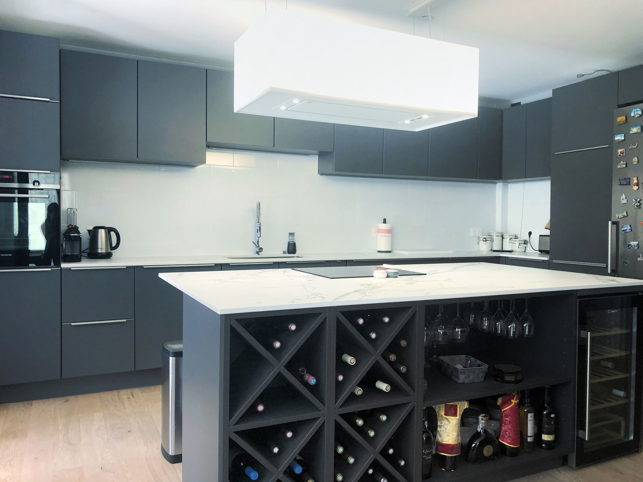 cuisine ouverte haut de gamme noire mate avec îlot plan de travail effet marbre et cave à vin par Cuisine Intérieur Design Toulouse
