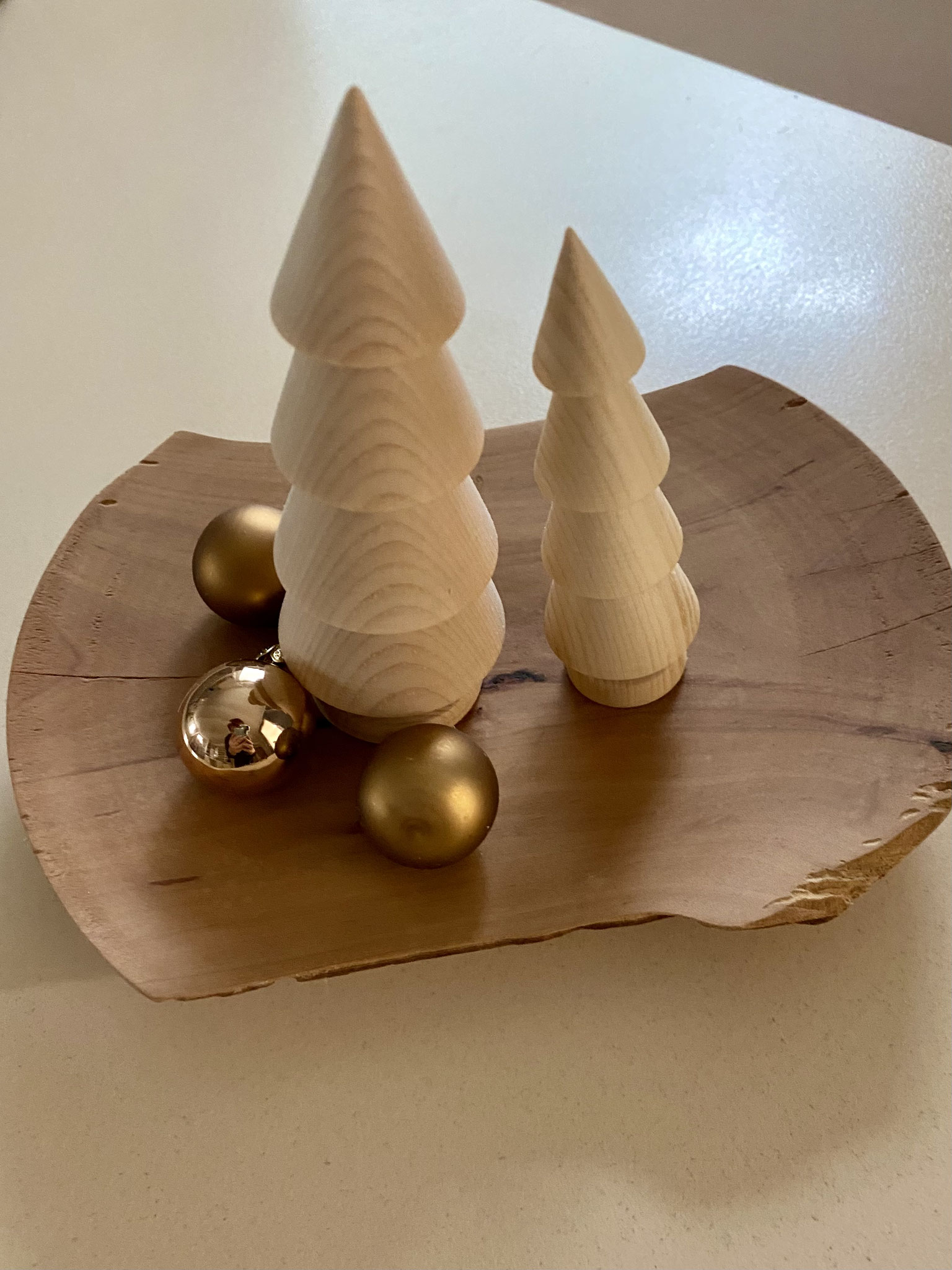 Hand gedrechselt te Tannenbäumen chen stehen auf einer Holzschale mit kleinen Glöckchen zur Dekoration.