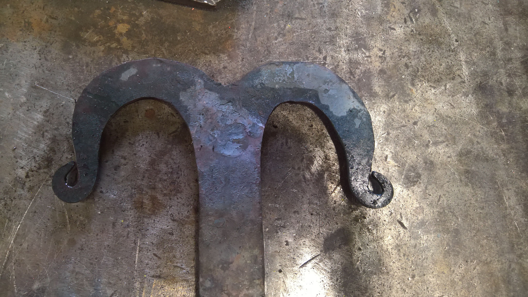 Die "Kringel" werden mit Zange und Hammer eingerollt. Hier in der Abbildung ein "Kringel", welcher eher in die Gotik passt.
