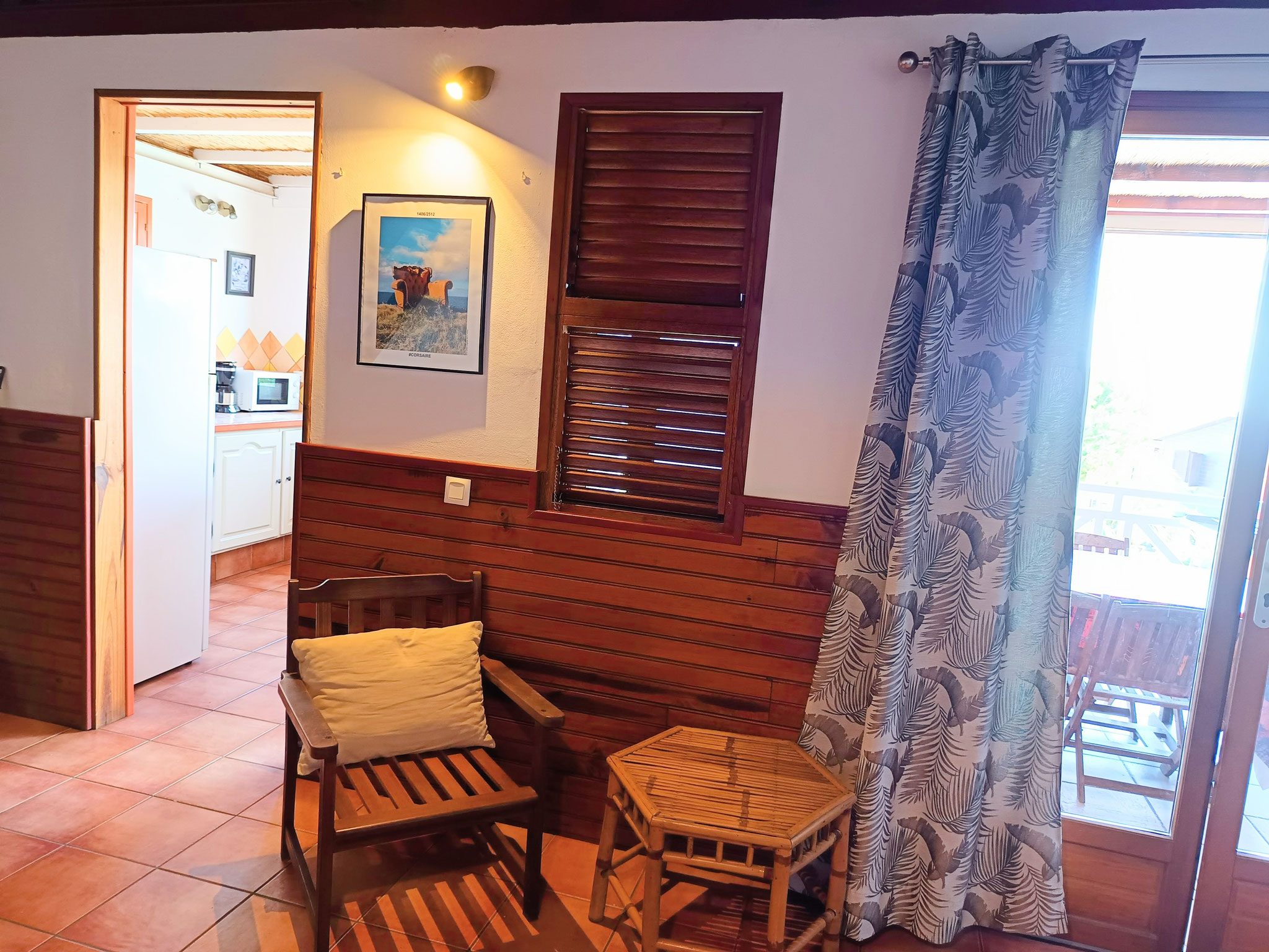 Séjour bungalow n°9 – table et chaises, volets bois, luminaire tamisé