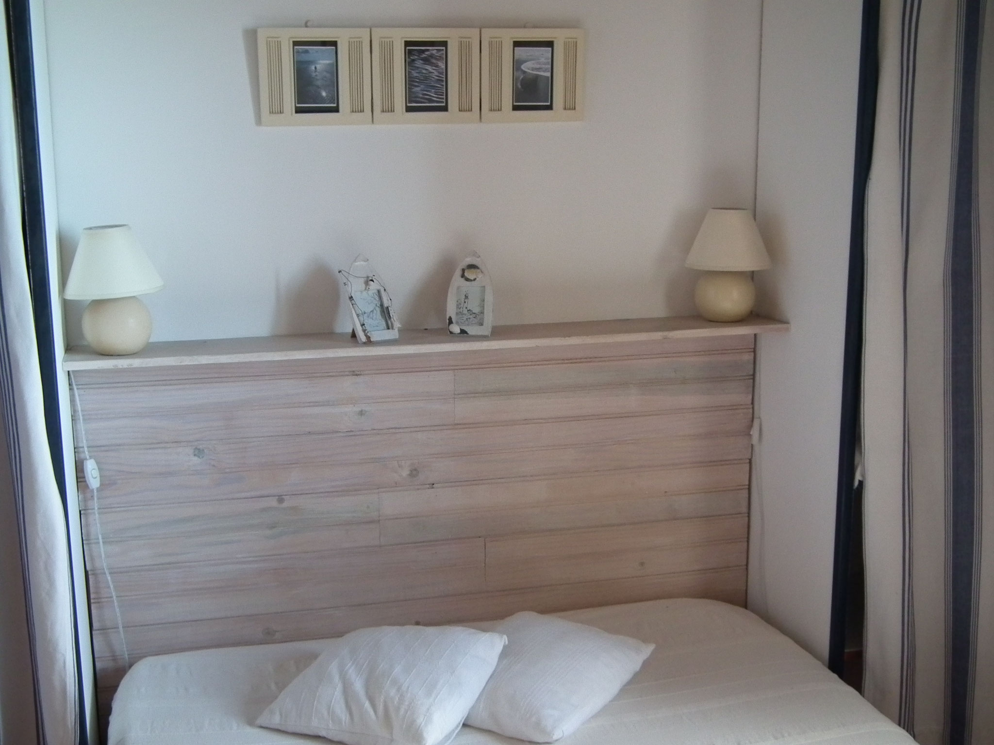 Double bedroom with wooden headboard shelf and white bedding, Bungalow 9, furnished bungalow Saint-Leu