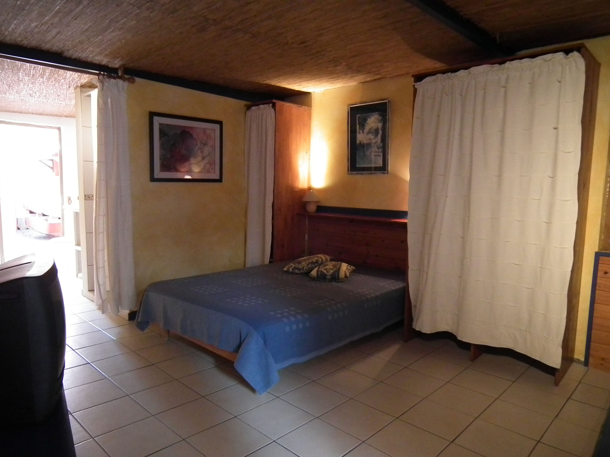 Chambre 1 rez-de-chaussée bungalow n°10 – lit double, rideau de séparation, décoration